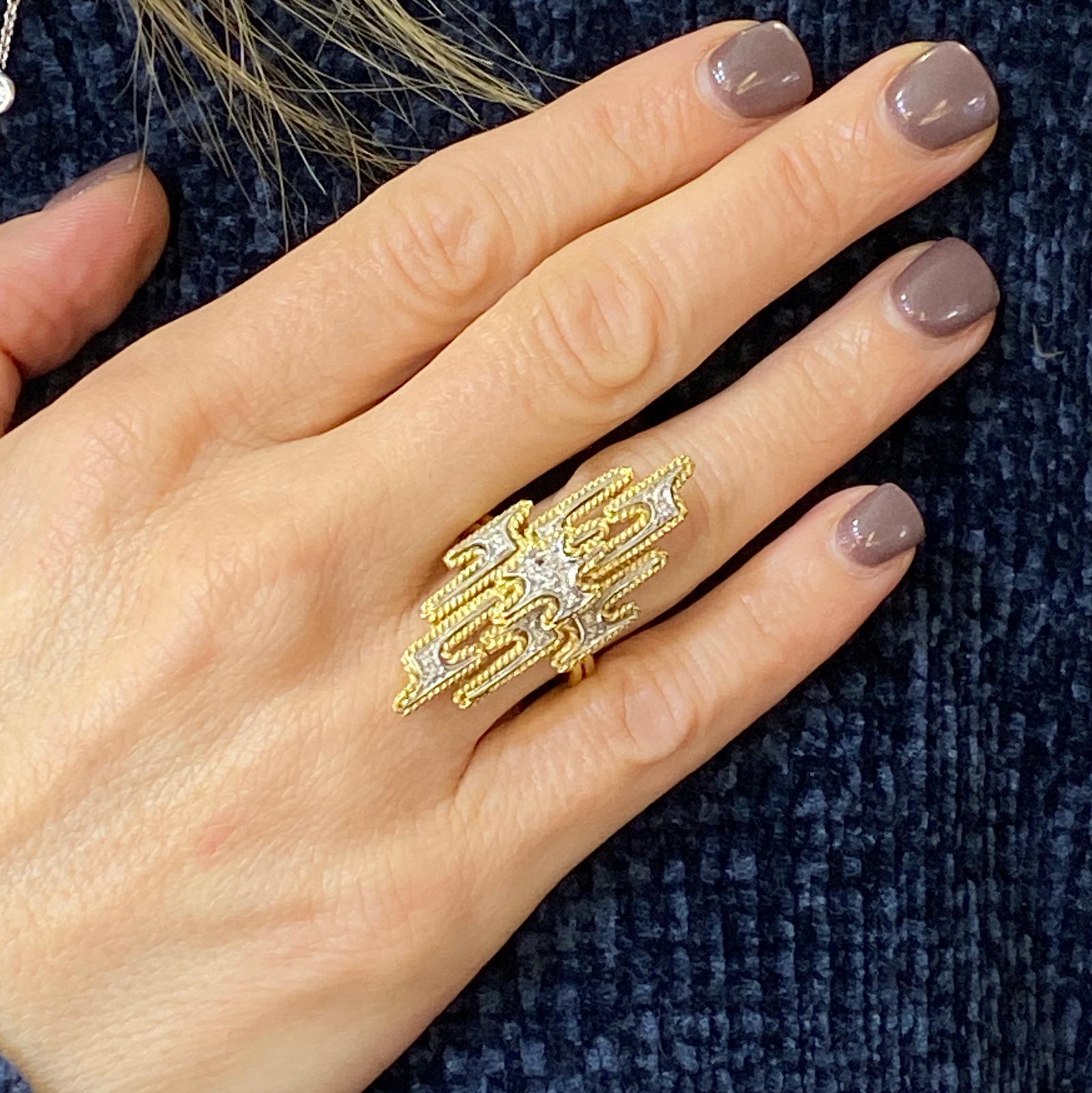 Fabulous 1970's diamond ring fashioned in 18 karat white and yellow gold. The ring features 19 round brilliant cut diamonds weighing .19 carat total weight and graded G-H color and SI clarity. The elongated ring measures 1.6 inches in length, .70
