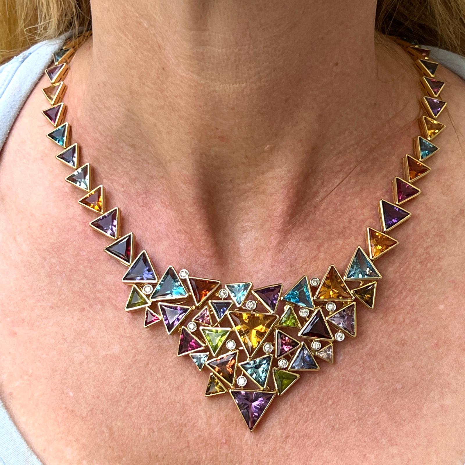 Fabulous and colorful bib link necklace crafted in 18 karat yellow gold. The necklace features multi-color citrine, amethyst, peridot, and topaz gesmtones and 14 round brilliant cut diamonds weighing approximately 1.40 CTW. The diamonds are graded