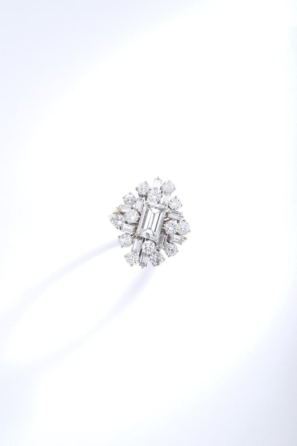 Emerald cut Diamond surround by Round cut Diamond mounted on platinum and yellow gold ring. Just stunning!
Circa 1970.