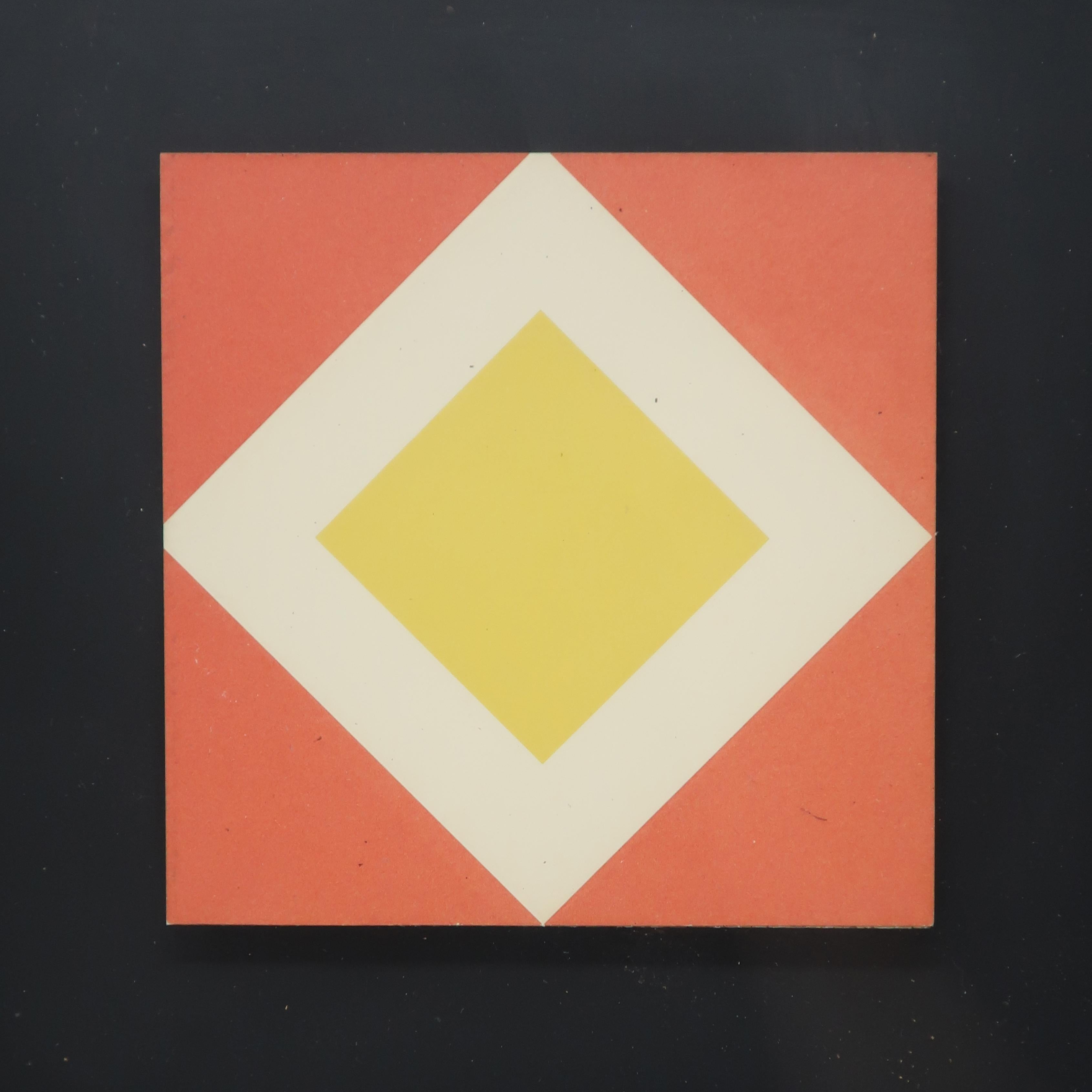 A small framed op art piece with a central yellow and white diamond on an orange background, all of which is raised off a black background. Behind glass in a brass colored aluminum frame with original turner wall accessories label.

Measures: 10”
