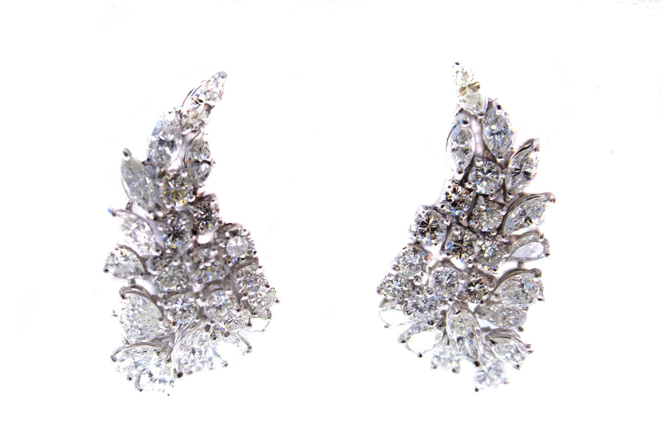 Masterfully hand-crafted in platinum these chic and luxurious diamond cluster earrings are shaped to flow elegantly up the ear. Set with 22 round brilliant cut diamonds, 16 pear shape and 12 marquis shape diamonds the total diamond weight has been