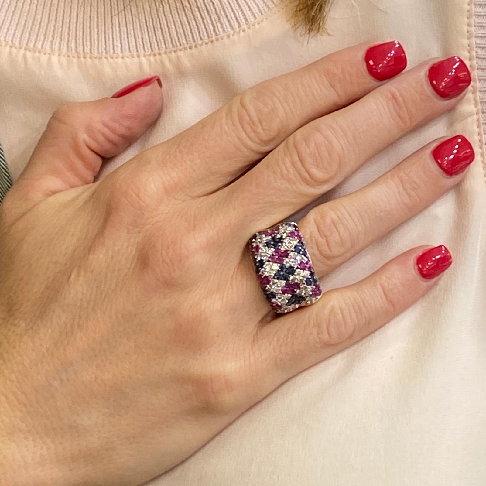 Colorful wide band ring circa 1970's. The band is set with ruby, sapphire, and diamonds in a diamond shape configuration. The ring features 46 round brilliant cut diamonds that equal approximately 1.38 carat total weight. Fashioned in 14 karat