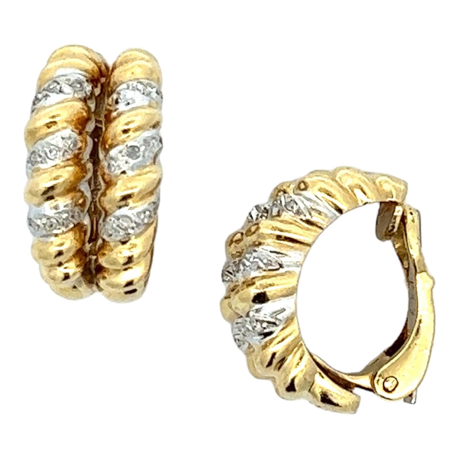 Two row round brilliant cut diamond earrings fashioned in 18 karat yellow gold spirals. The earrings feature 18 round brilliant cut diamonds weighing approximately .12 CTW and graded H-I color and SI clarity. The earrings measure.40 x .75 inches,