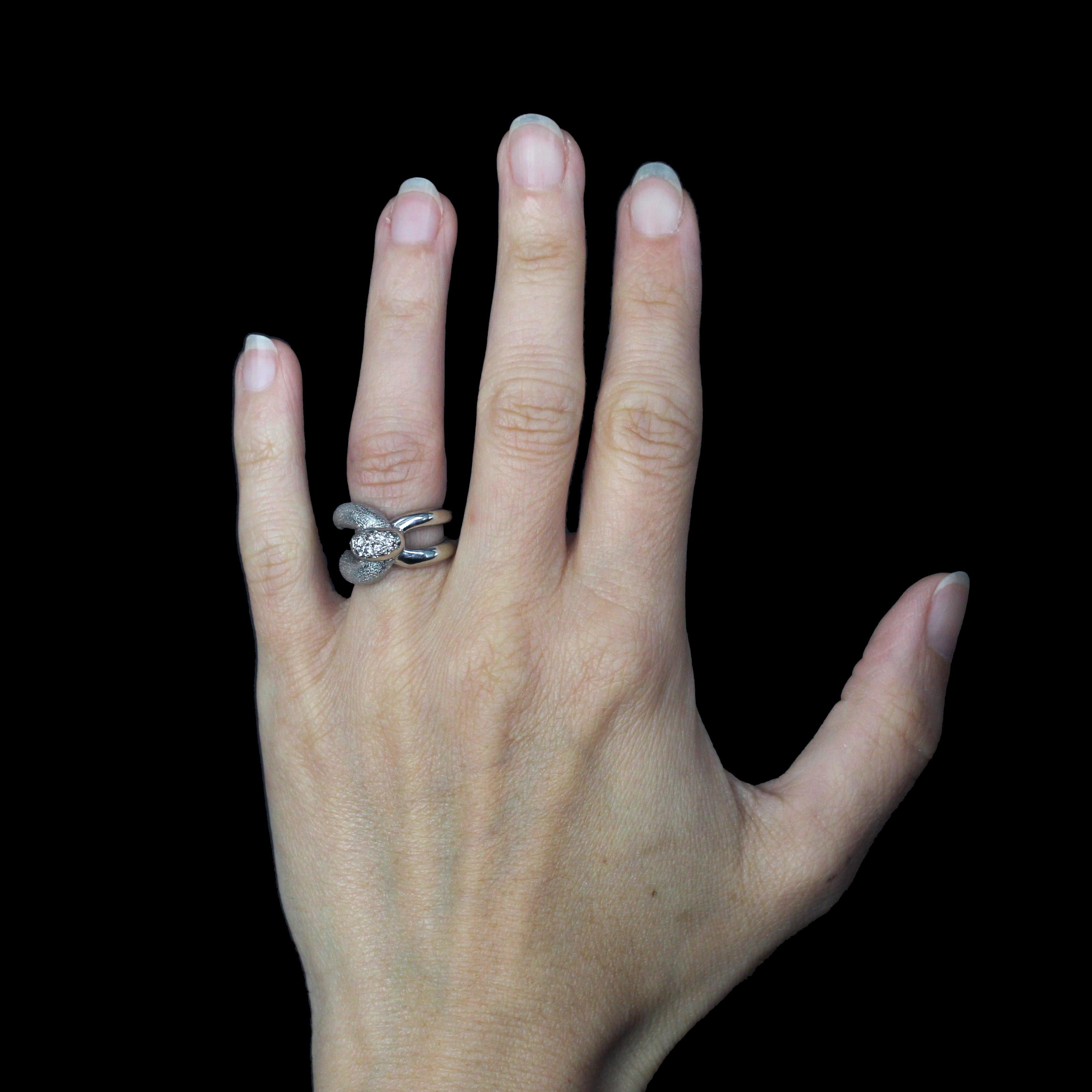 Anello in oro bianco 18 carati, marchio di garanzia testa di gazzella.
Progettato per essere indossato sul mignolo o su un dito molto sottile, questo anello vintage presenta un'ampia fascia doppia asimmetrica che si avvolge sul davanti come una