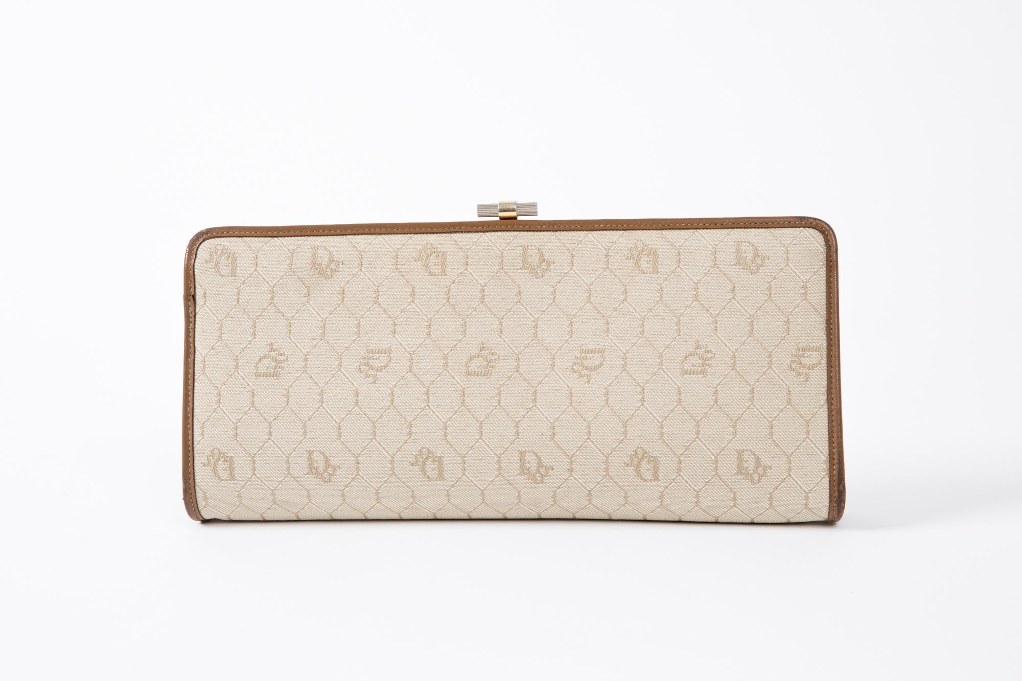 1970s Dior camel cotton canvas monogram logo clutch featuring an all over logo pattern with nut leather finishing, top logo claps opening, an inside logo stamp. 
Width 11in (28cm)
Height 5.5in. (14cm)
Depth 1.5in. (4cm)
In excellent vintage