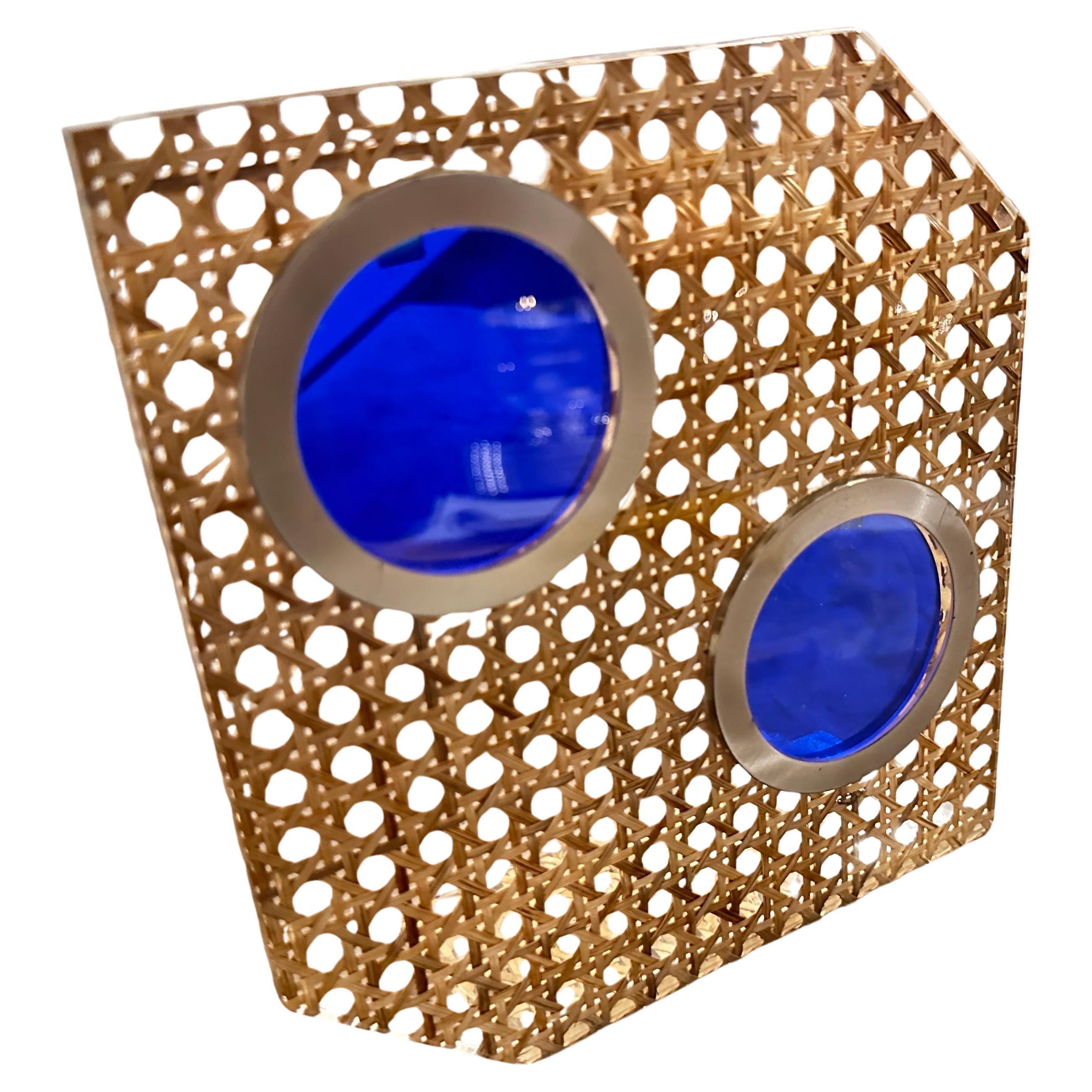 Este marco de fotos único se atribuye a Dior Home y data de la década de 1970. Está hecha de paja de Viena, un material natural tejido que añade textura y un aire orgánico a la pieza. El marco se inserta en una estructura geométrica de forma moderna