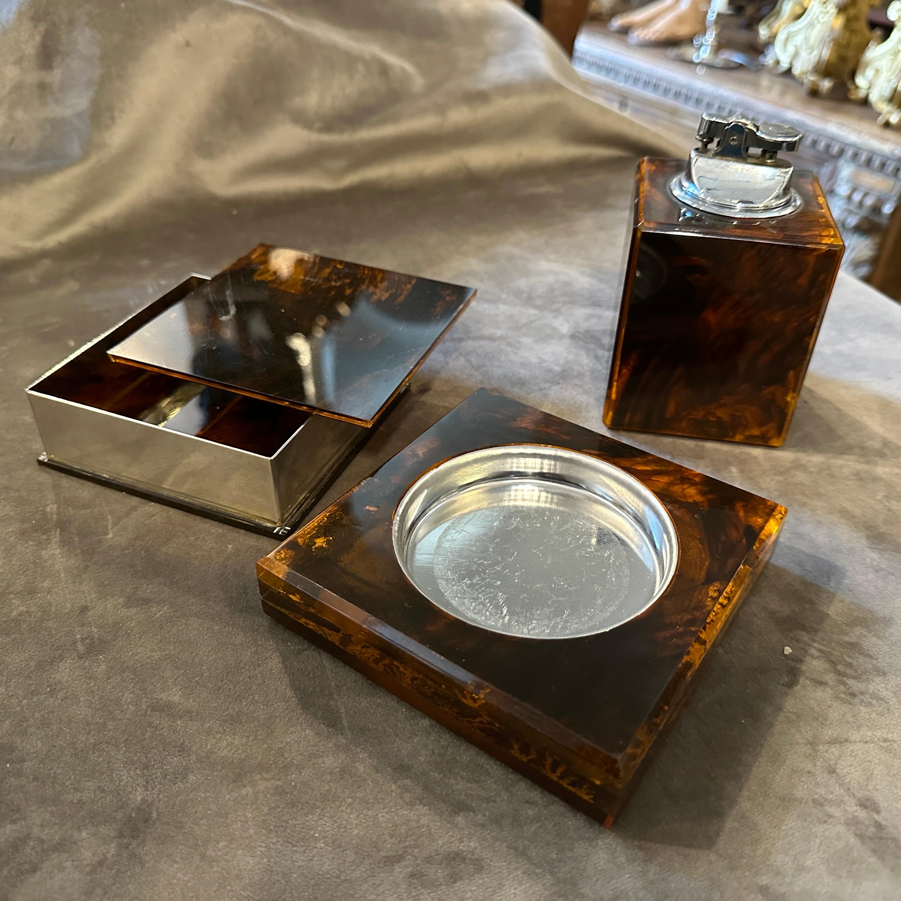 A fake tortoise lucite italian smoking set composed by an ashtray, a cigarette box and a lighter not tested. Box side dimension is 12 cm, ashtray side is 11 cm, The three items are in original condition, small signs of use and age visible on the