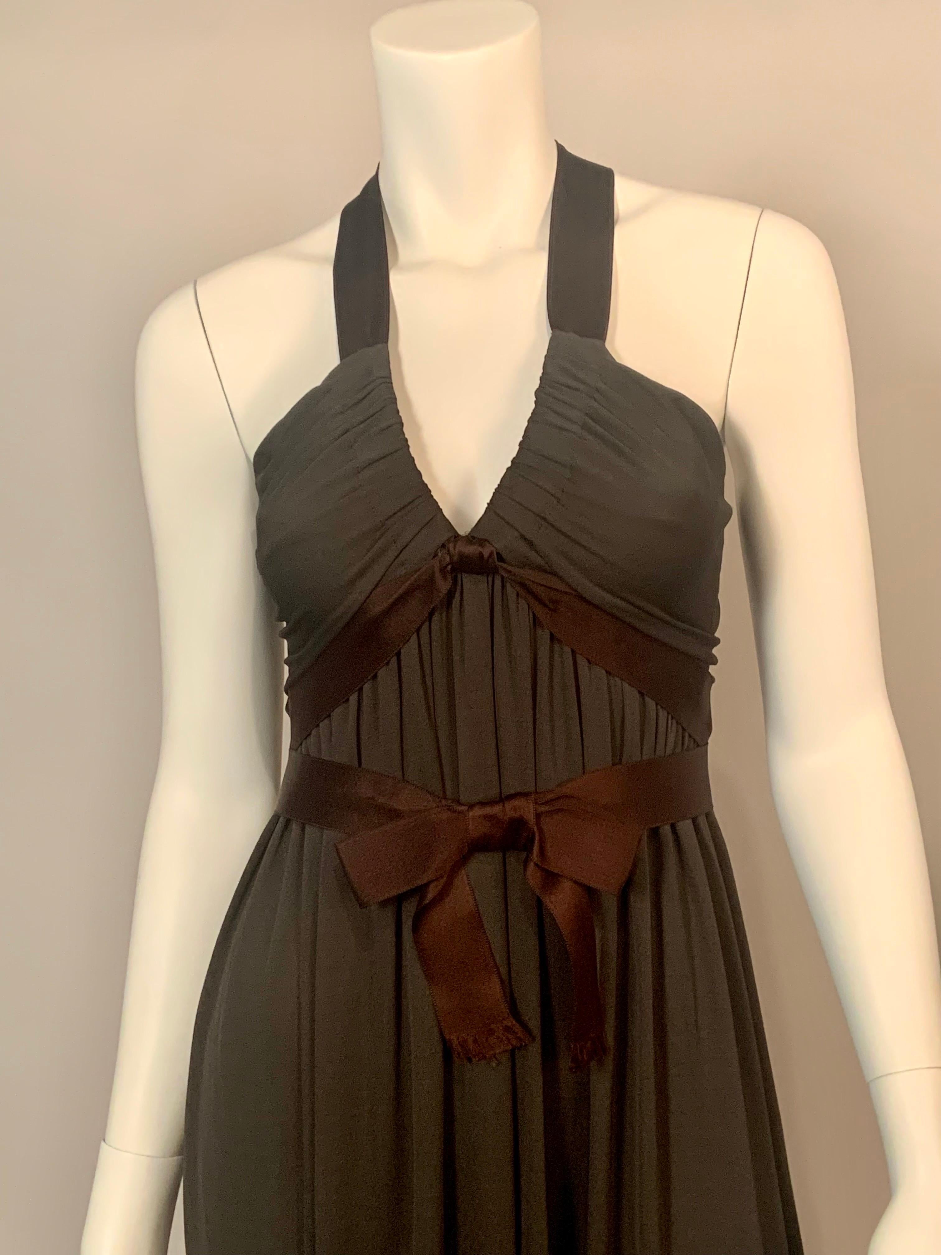 This  is a sexy 1970's dress designed by Donald Brooks. The body of the dress is dark brown jersey and the bodice is trimmed with chocolate brown satin ribbon which is used to create the halter neckline and  the straps at the back.  It is also used