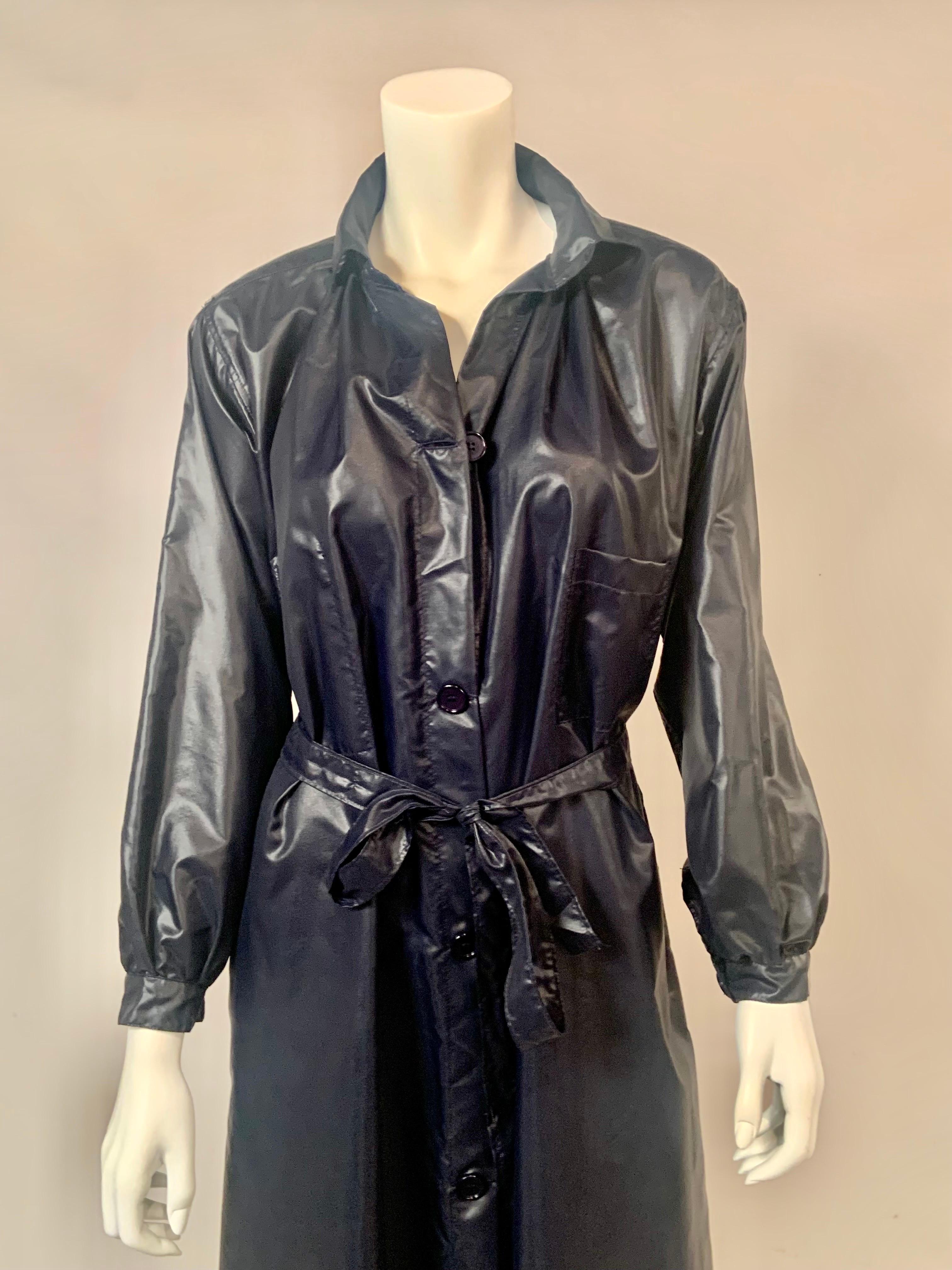 This 1970's navy blue rain slicker designed by Dorothee Bis for Henri Bendel in New York City will keep you stylishly dry on a rainy day.  The coat has five buttons at the center front, a left side breast pocket and a right side interior breast