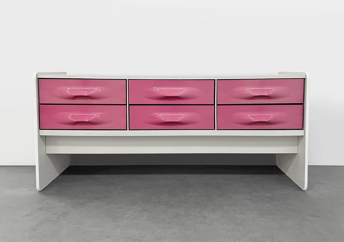 This vintage dresser was designed by Giovanni Maur for Treco circa 1970 and is reminiscent of Raymond Loewy's DF2000 series. This piece features the less common pink ABS molded drawer fronts and would also make a great entertainment unit. In good