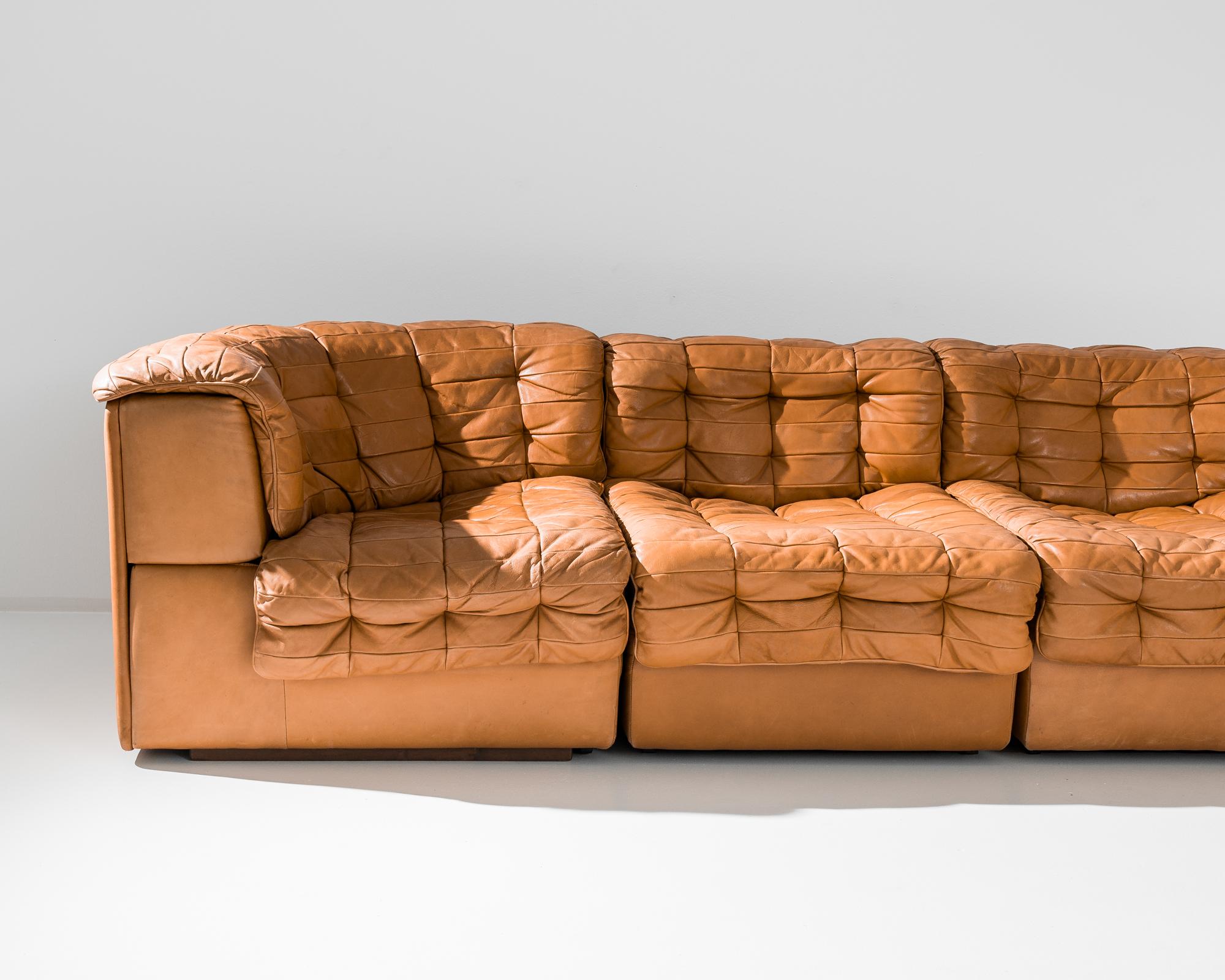 An upholstered leather modular sofa made circa 1970 by the iconic company De Sede, a Swiss manufacturer of exclusive furniture. A stunning tawny angled sofa, this hand-crafted leather piece lays full focus on comfort and authentic design. The cubic