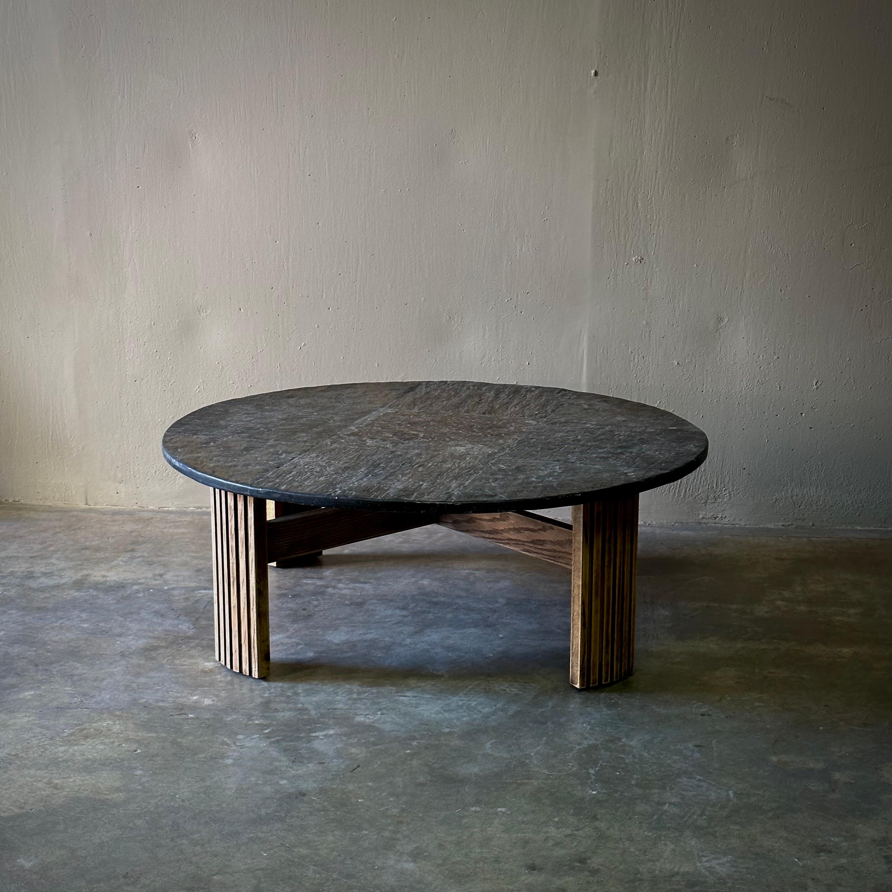 Dutch 1970s slate coffee table with circular top and striated modernist wood legs. Cool and earthy with a sleek midcentury silhouette. Would work well in both indoor and outdoor spaces alike.

Netherlands, circa 1970.

Dimensions: 41.3W x 41.3D x