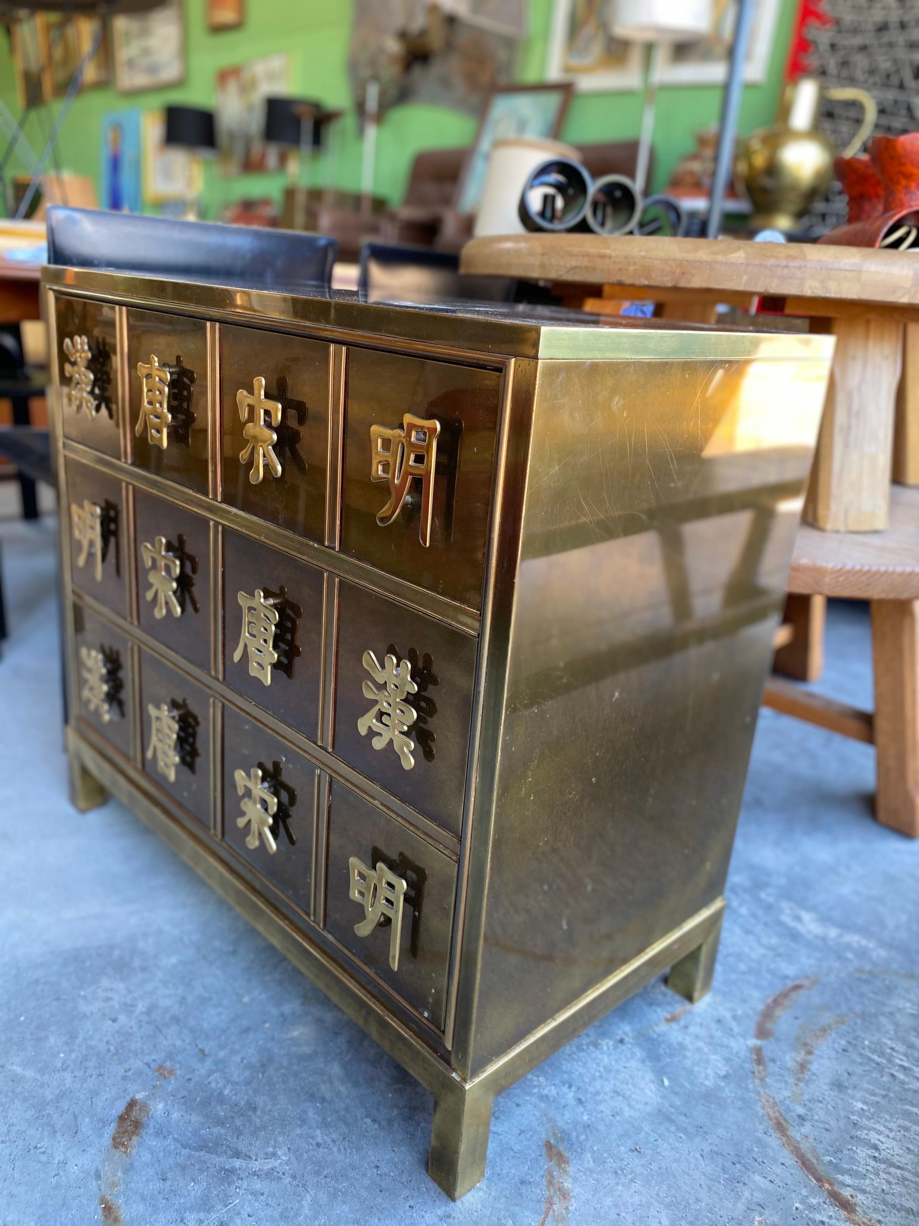 Beautiful dynasty brass chest of drawers by Mastercraft. The chest includes pulls designed with Chinese characters which represent the four dynasties. Features three drawers and is in good overall vintage condition. Normal wear as shown in images.