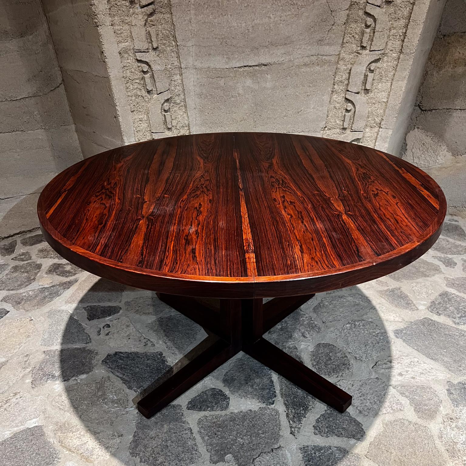 Danish Modern 1970s Scandinavian Rosewood Dining Table.
Attribution Dyrlund, unsigned.
Round to large oval extended.
Solid wood legs. Round top in plywood with book matched rosewood veneer.
Clean modern design. Table has two extensions.
51 diameter