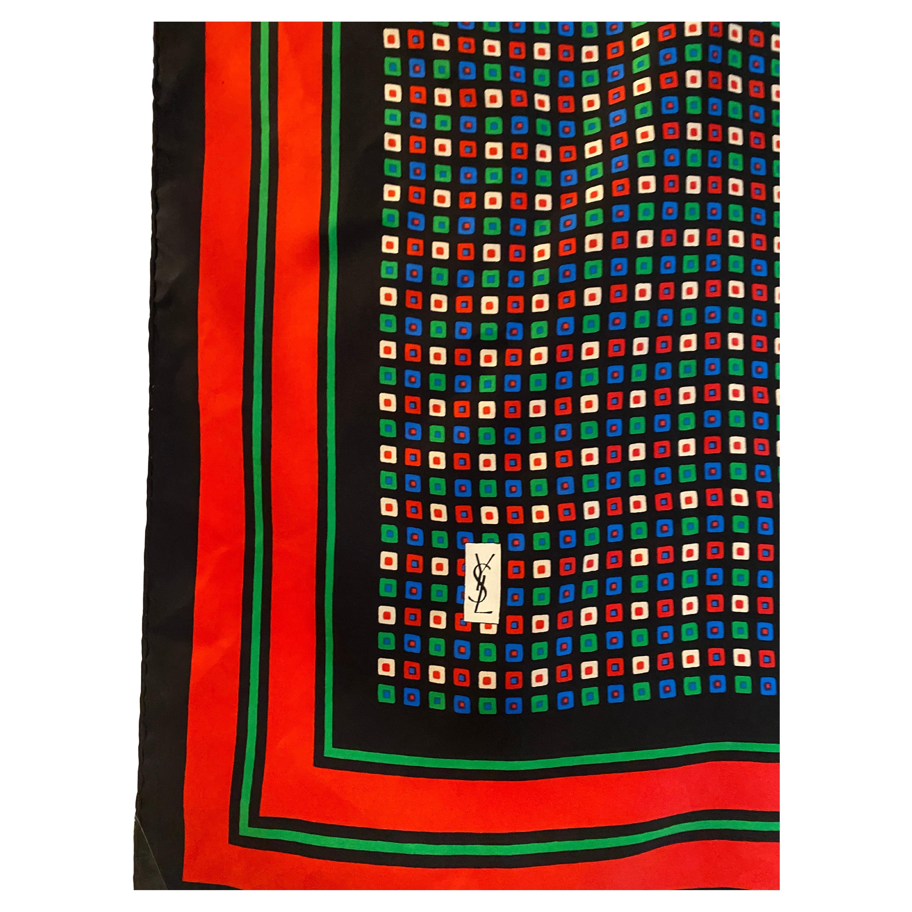 Sciarpa vintage in seta di Yves Saint Laurent (YSL) con una fitta stampa quadrata geometrica multicolore su fondo nero intenso, incorniciata da un audace bordo a righe rosse e verdi: un esempio lampante dei design grafici di YSL per gli accessori.