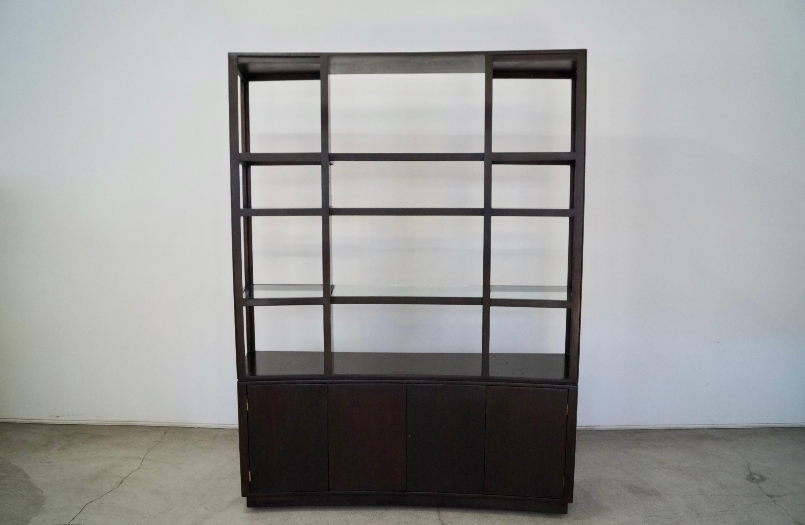 Vintage Mid-century Modern shelf for sale. It was manufactured in the 1970's by Dunbar, and designed by Edward Wormley. It has a lower credenza with cabinets and a drawer and shelves. It has a hutch that sits on top of the credenza with glass