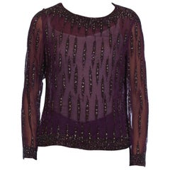 Blusa de manga larga de gasa de poliéster color púrpura berenjena de la década de 1970 con cuentas y cristales