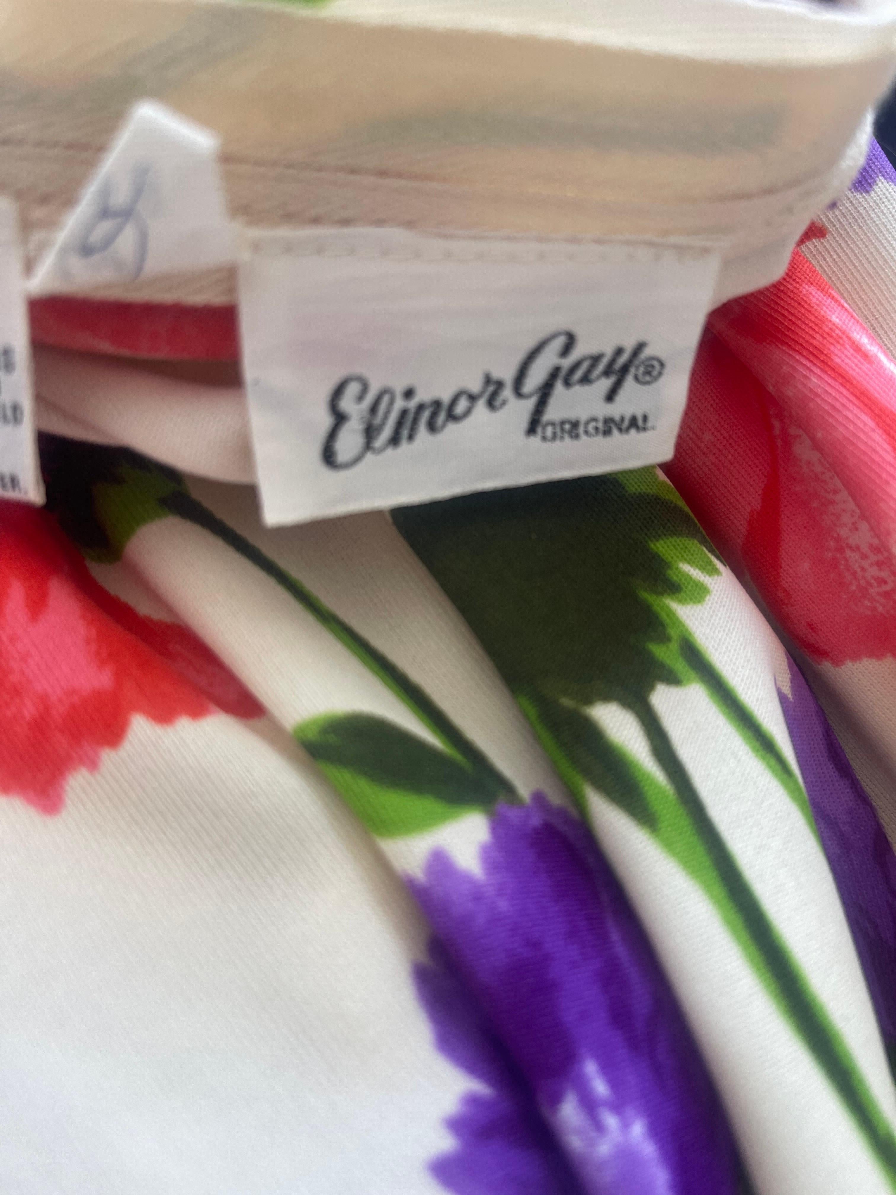 Beautiful early 70s Elinor Gay flower printed jersey maxi dress ! Ivory / off - white dress with colorful florals printed in purple, green, pink, and yellow throughout. Hidden zipper up the back with hook-and-eye closures. Very well made, with lots