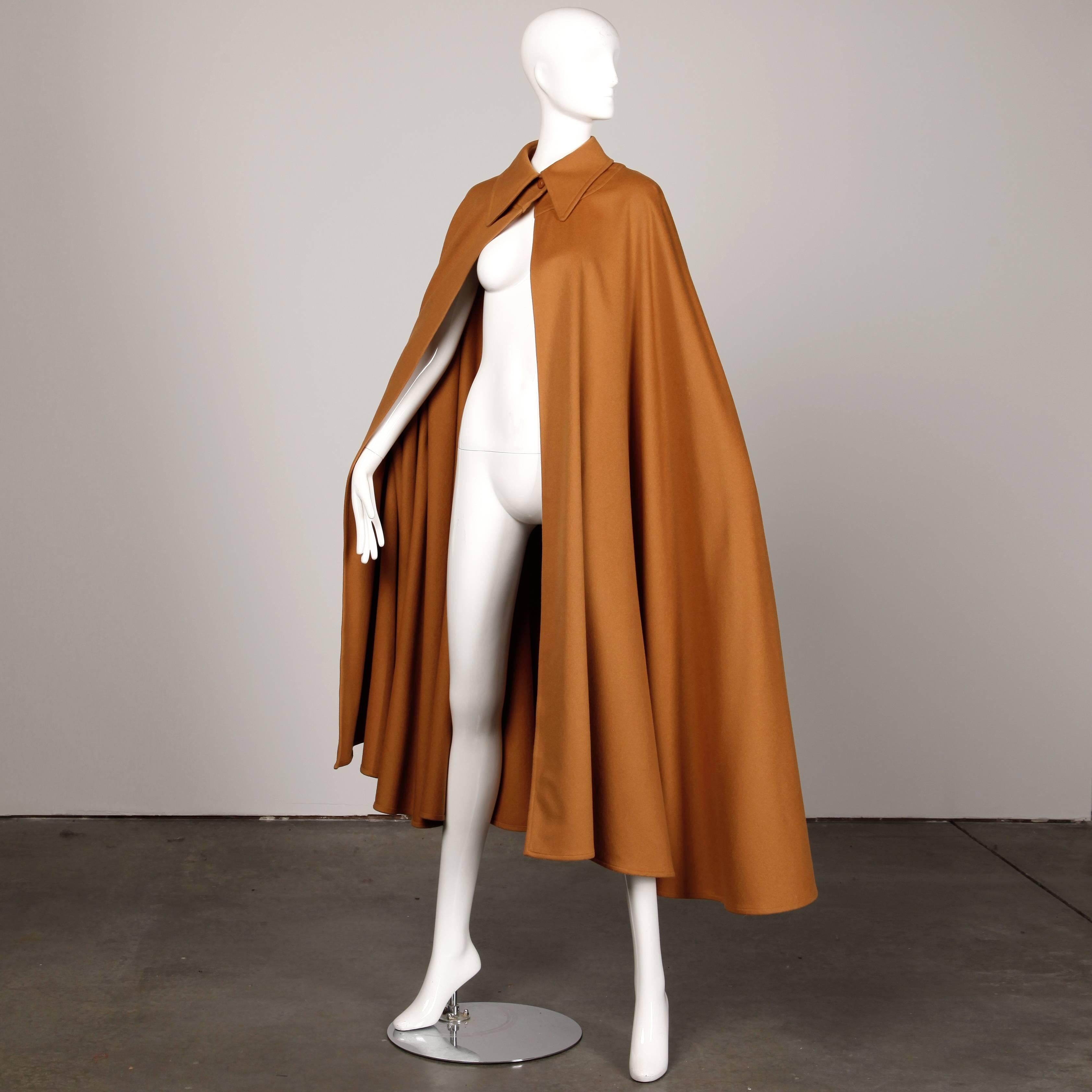 Incroyable manteau cape vintage en laine épaisse d'Emanuel Ungaro datant des années 1970. Fermeture à bouton unique sur le devant du cou. Belle laine de couleur camel. Non doublé. Cette cape devrait convenir à la plupart des tailles grâce à sa forme