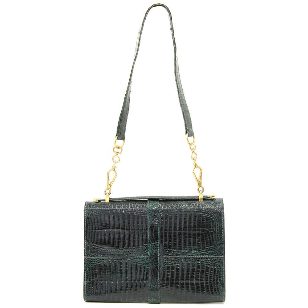 Stunning, sexy baby crocodile leather purse from 1970s. Its emerald green colour is absolutely stunning and makes it perfect from day to night. Features two pockets and one zip pocket in the inside. The strap is part leather part golden chain and