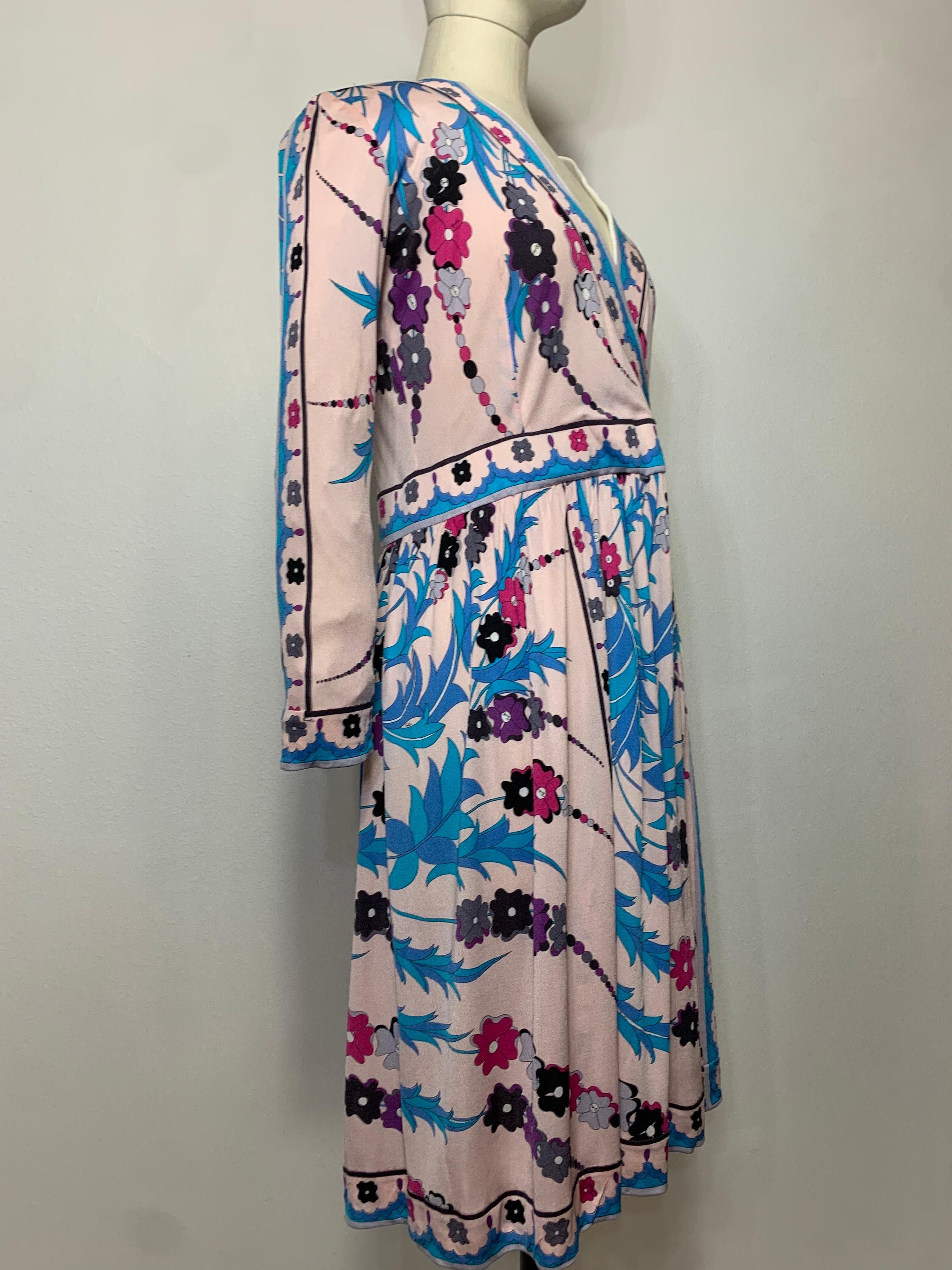 1970s Emilio Pucci Silk Jersey Floral Print Faux-Wrap Dress w Full Skirt & Banded Hem and Sleeve Trim: An unusual print in pale pink with stylized gladiolas in turquoise, purple and black. Coordinating banded waist,  neckline, hem and cuffs.