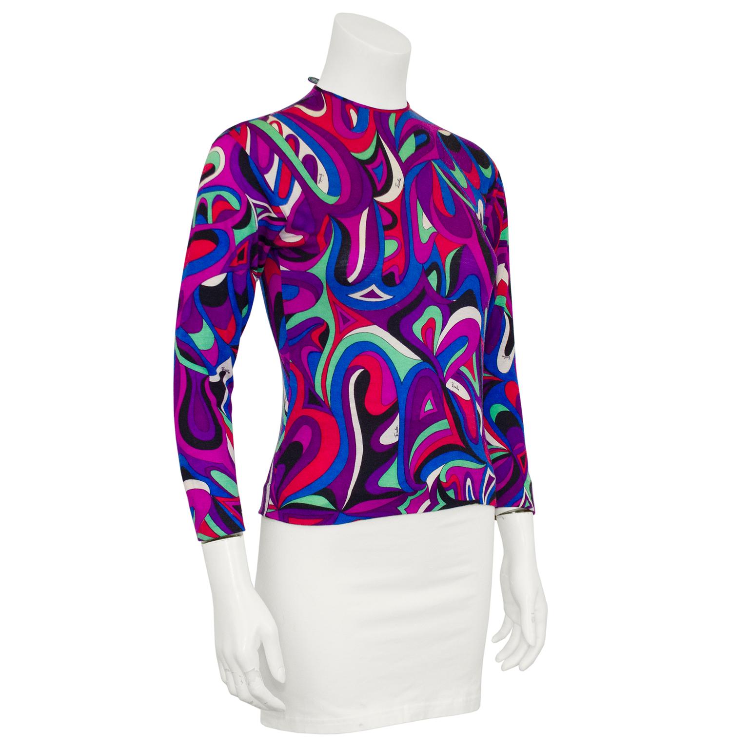 Beautiful Emilio Pucci very light weight pull over sweater from the 1970s. Made from 100% wool, this sweater features the iconic Emilio Pucci brand abstract print in tones of dark purples, blues, red, pink and mint green. Crew neckline and bracelet