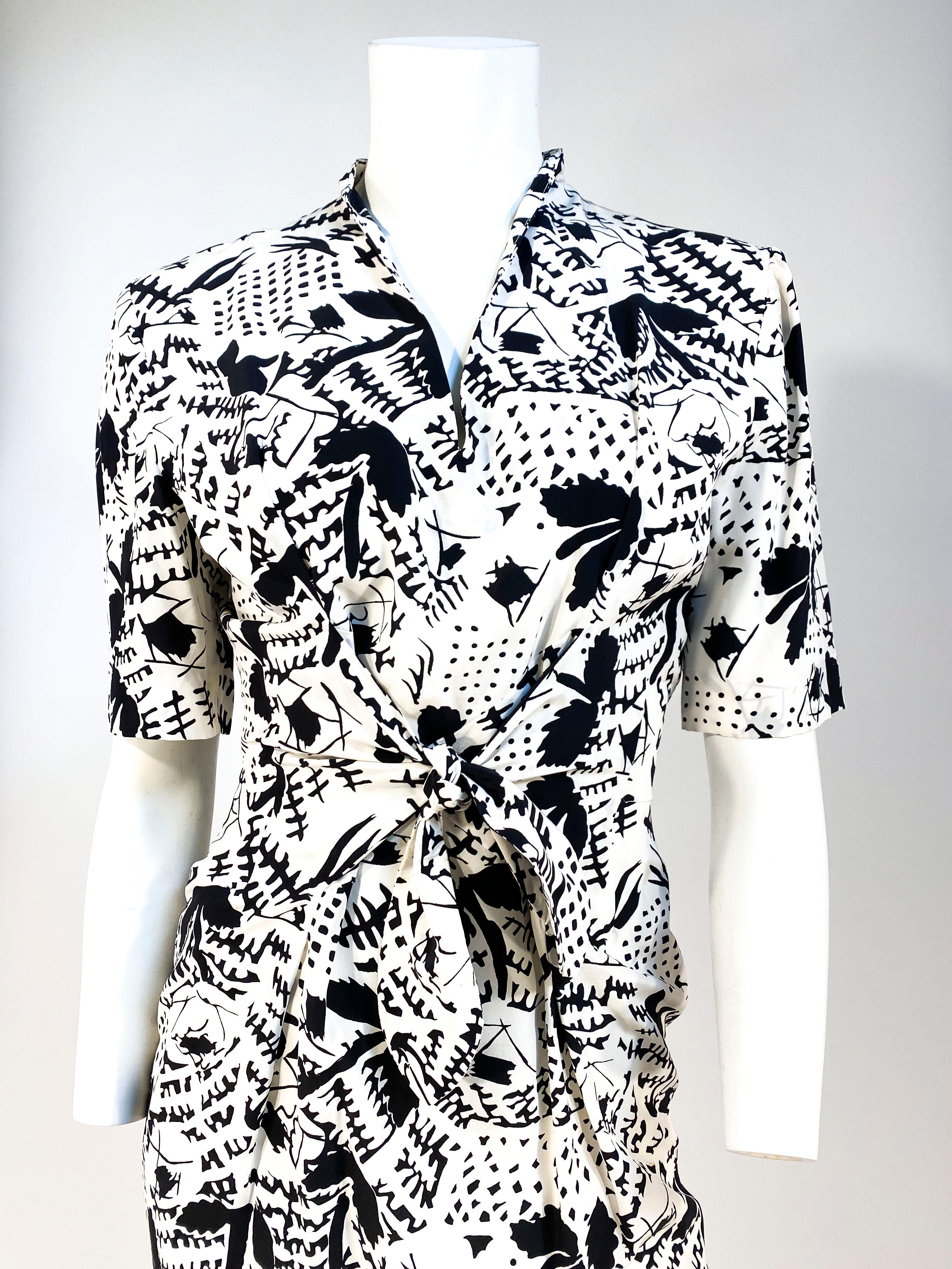 Late 1970s to early 1980s black and white Emmanuelle Khanh silk dress featuring an abstract print. The sleeves are elbow length with minor bathing on top of the shoulder and the was it has center panels that have a a sailor type tie for a proper