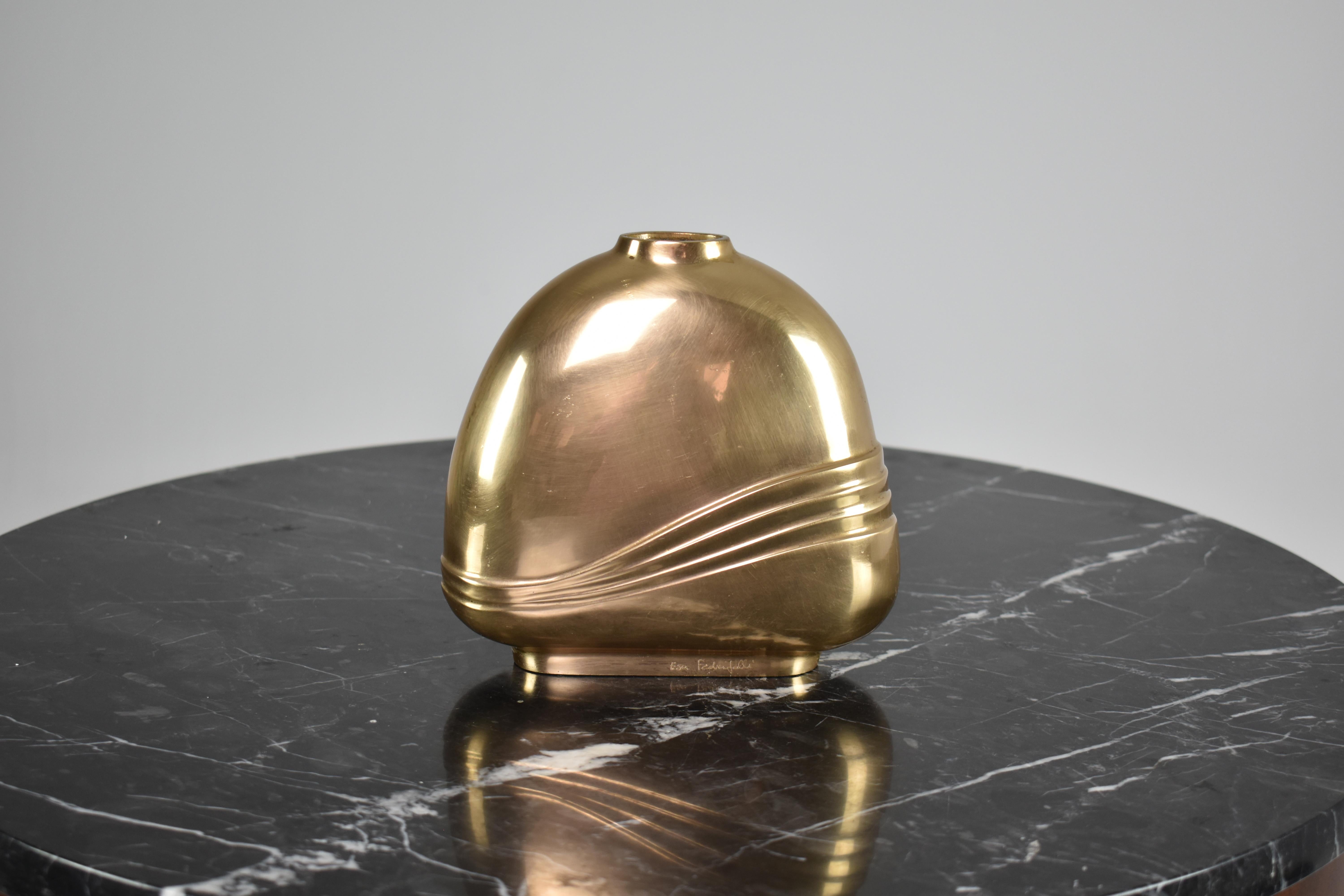 A beautiful bronze vase from the 1970s, handcrafted in Italy signed by the renowned artist Esa Fedrigolli. This organically shaped decorative piece features intricate engravings in the form of lines in the shape of waves. Its elegant design and