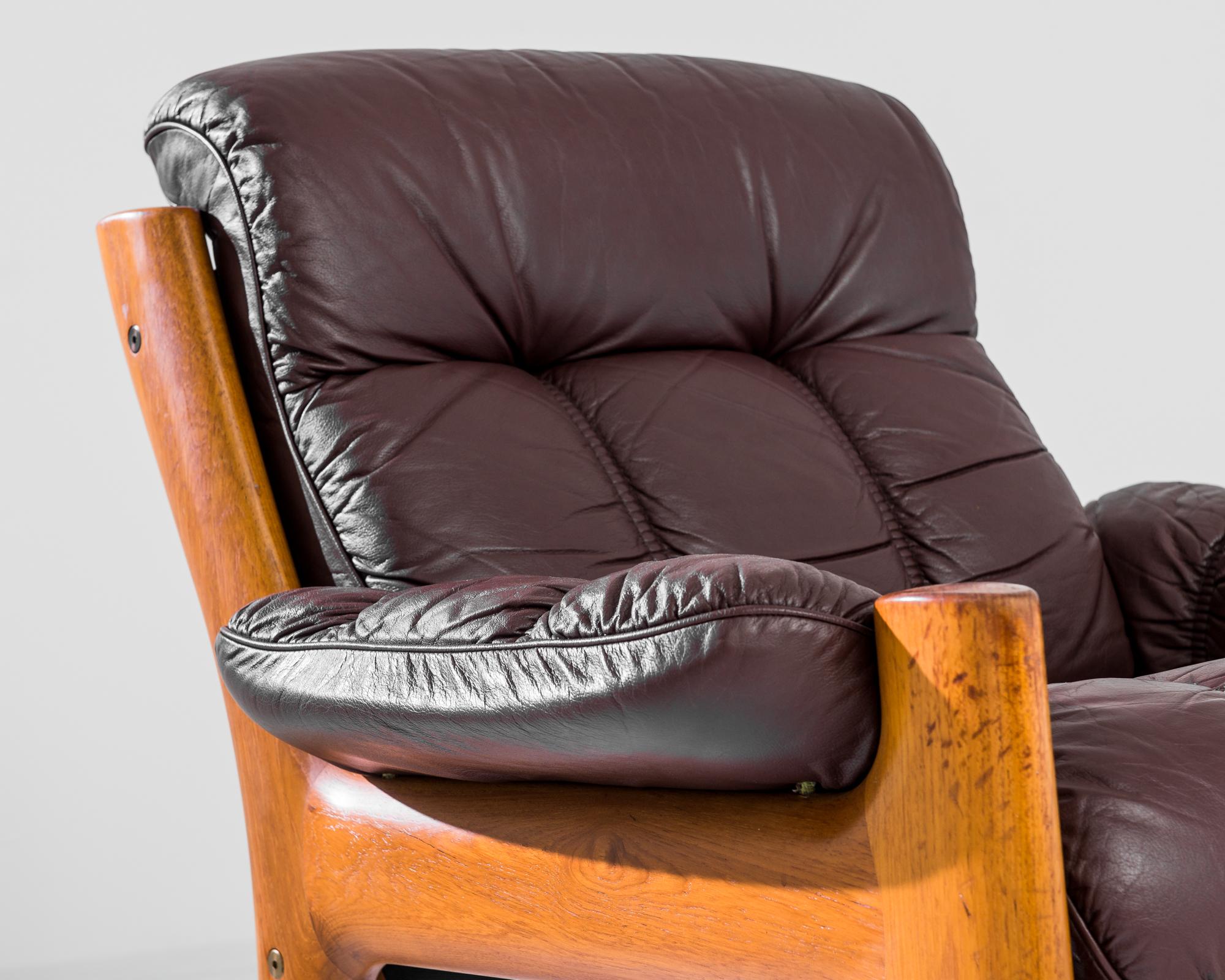 A 1970s armchair by Norwegian furniture designer Ekornes. Polished teak and deep oxblood leather offer a lively interplay of rich colors. The sophisticated segmentation of the upholstery creates an elegant seat, while the organic lines of the teak