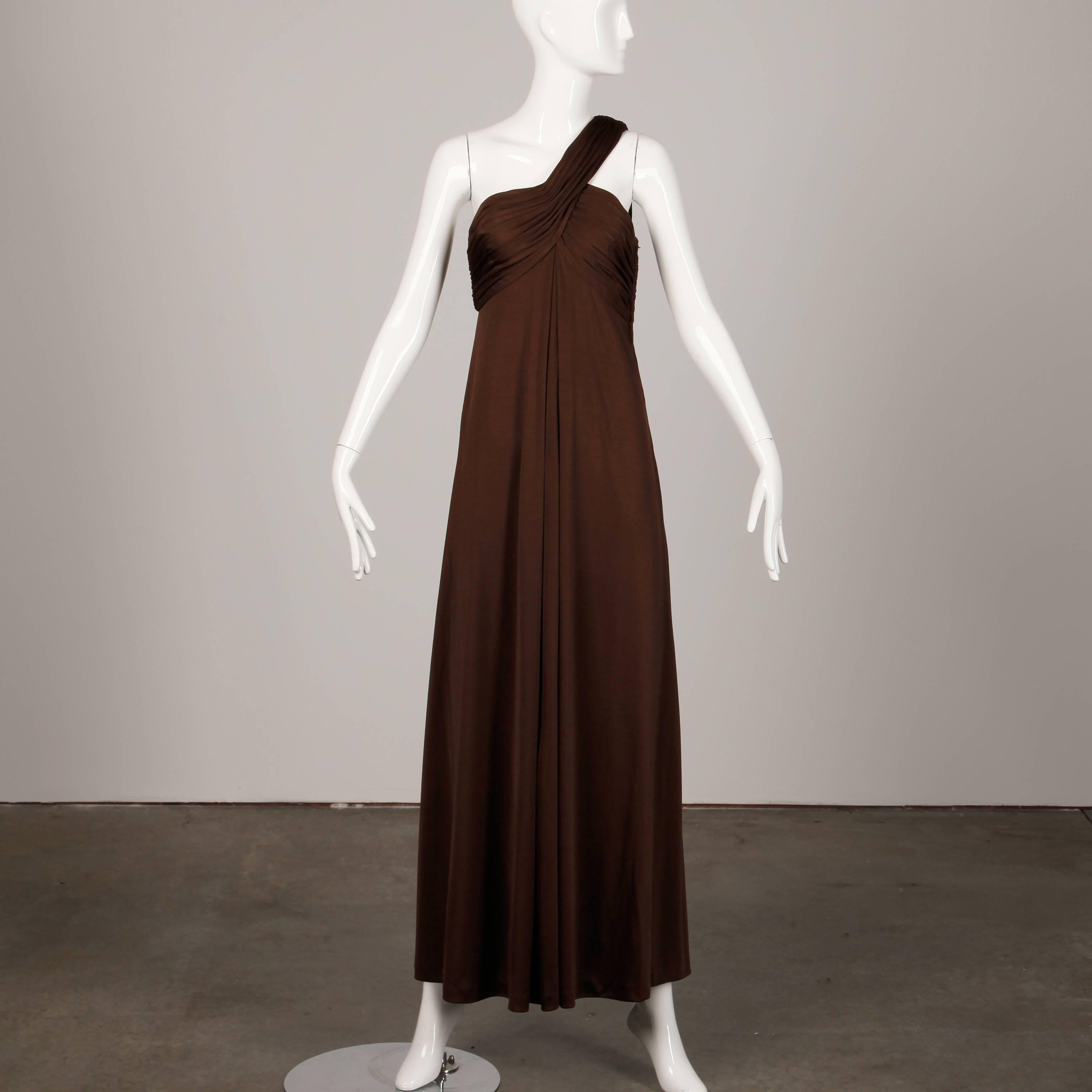 Gorgeous vintage brown jersey knit one-shoulder dress by Estevez. Fully lined, with side zip and hook closure and shoulder hook closure. Light weight slinky high quality jersey knit 100% polyester. The marked size is 6, but the dress fits like a