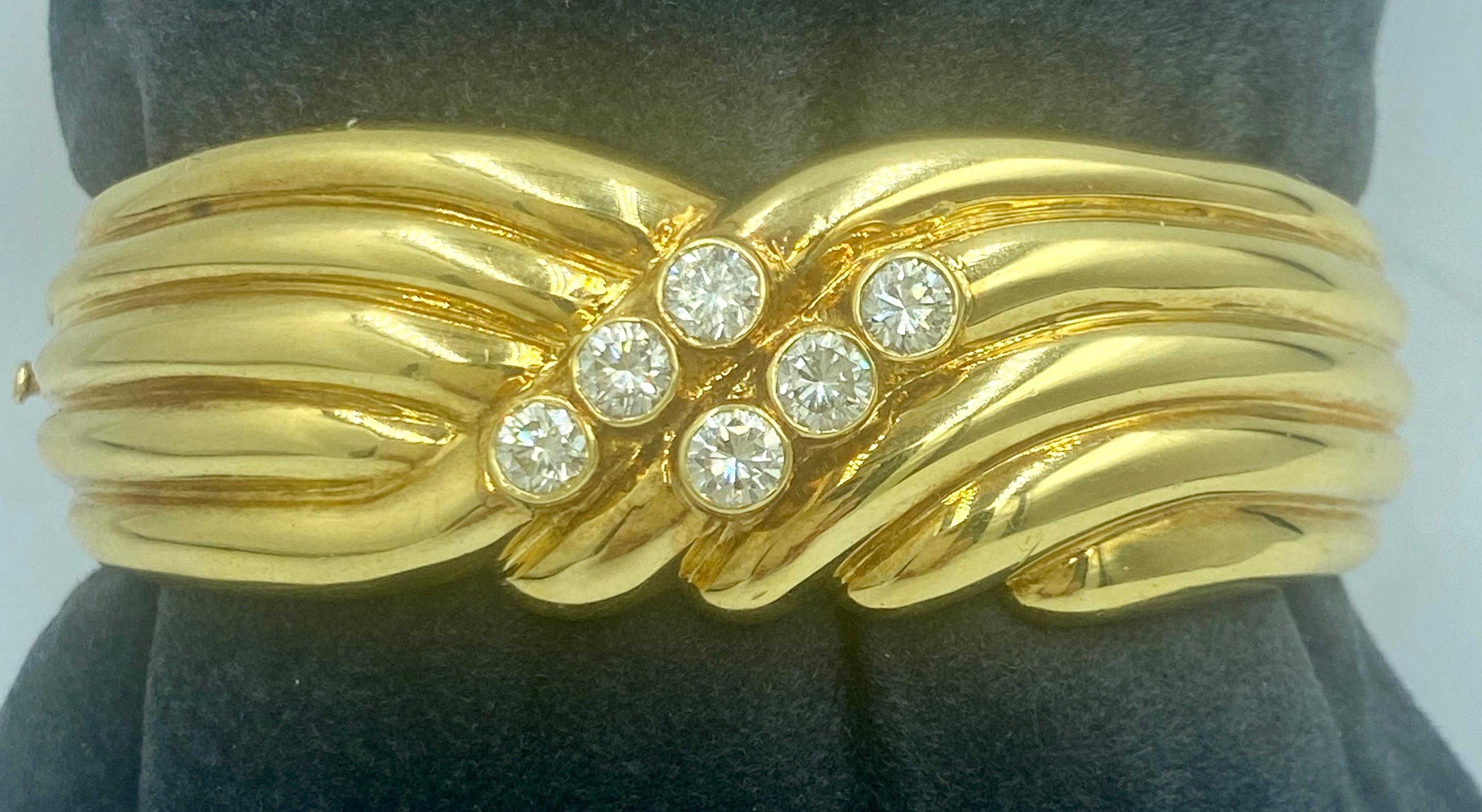 A beautifully chunky 18k gold cuff European made in 1970s, this bangle has a striking swirl design which is accented with 6 round cut diamonds totalling 1.56 carats. The inner circumference of the cuff measures 18cm. It is a stunning piece.
