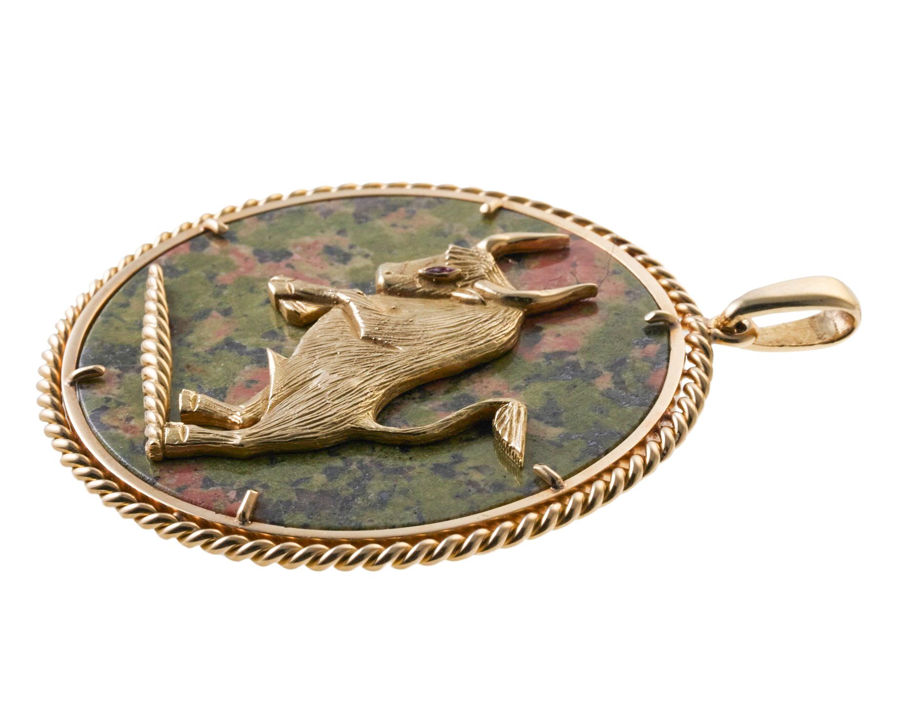 Vintage, circa 1970s 14k gold large pendant, depicting a bull or Taurus Zodiac sign. Set with inlay exotic gemstone, and ruby bull's eye. Pendant is 2.25