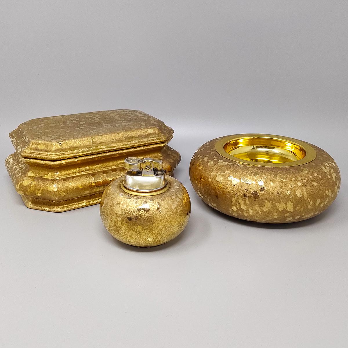 1970er Jahre Exquisites handgefertigtes Räucherset aus Keramik und  Blattgold. Hergestellt in Italien. Das Tischfeuerzeug funktioniert perfekt. Dieses Raucherset ist in ausgezeichnetem Zustand.
Abmessungen:
Tischfeuerzeug
Durchmesser 3,14 x 3,14 H