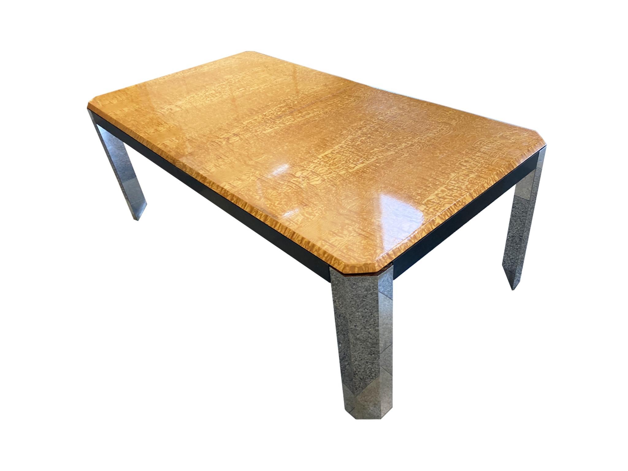 1970s extendable dining table in the style of Milo Baughman. This table combines Mid-Century Modern simplicity with the embellishment of materials like burlwood and chrome. The tabletop is patterned with a honey-yellow burl, while the legs are