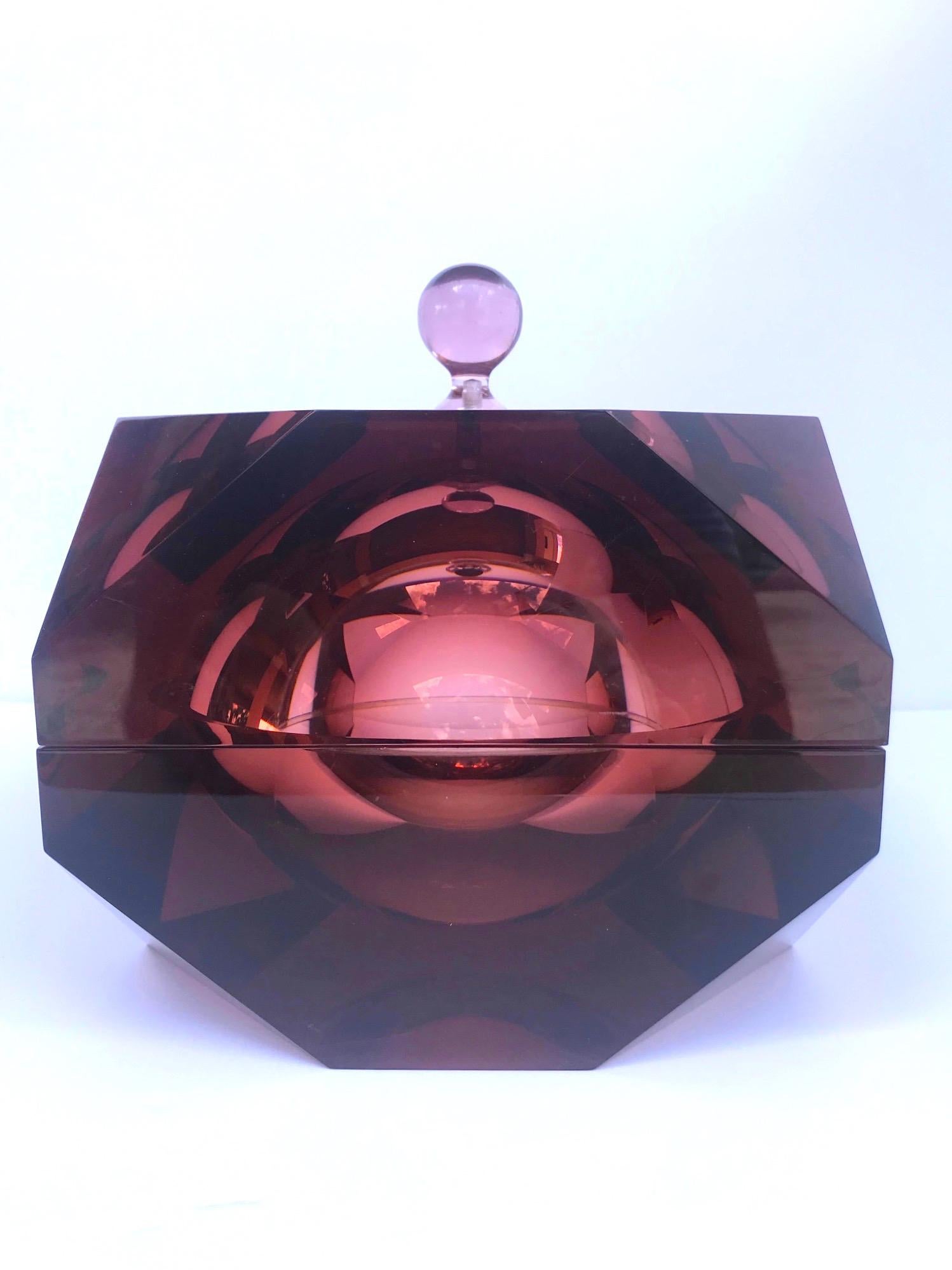 Exceptional Mid-Century Modern ice bucket with unique purple amethyst color. Carved from a solid Lucite block, the ice bucket has faceted prism design resembling a precious stone or a diamond. Interior sphere illuminates and reflects surrounding