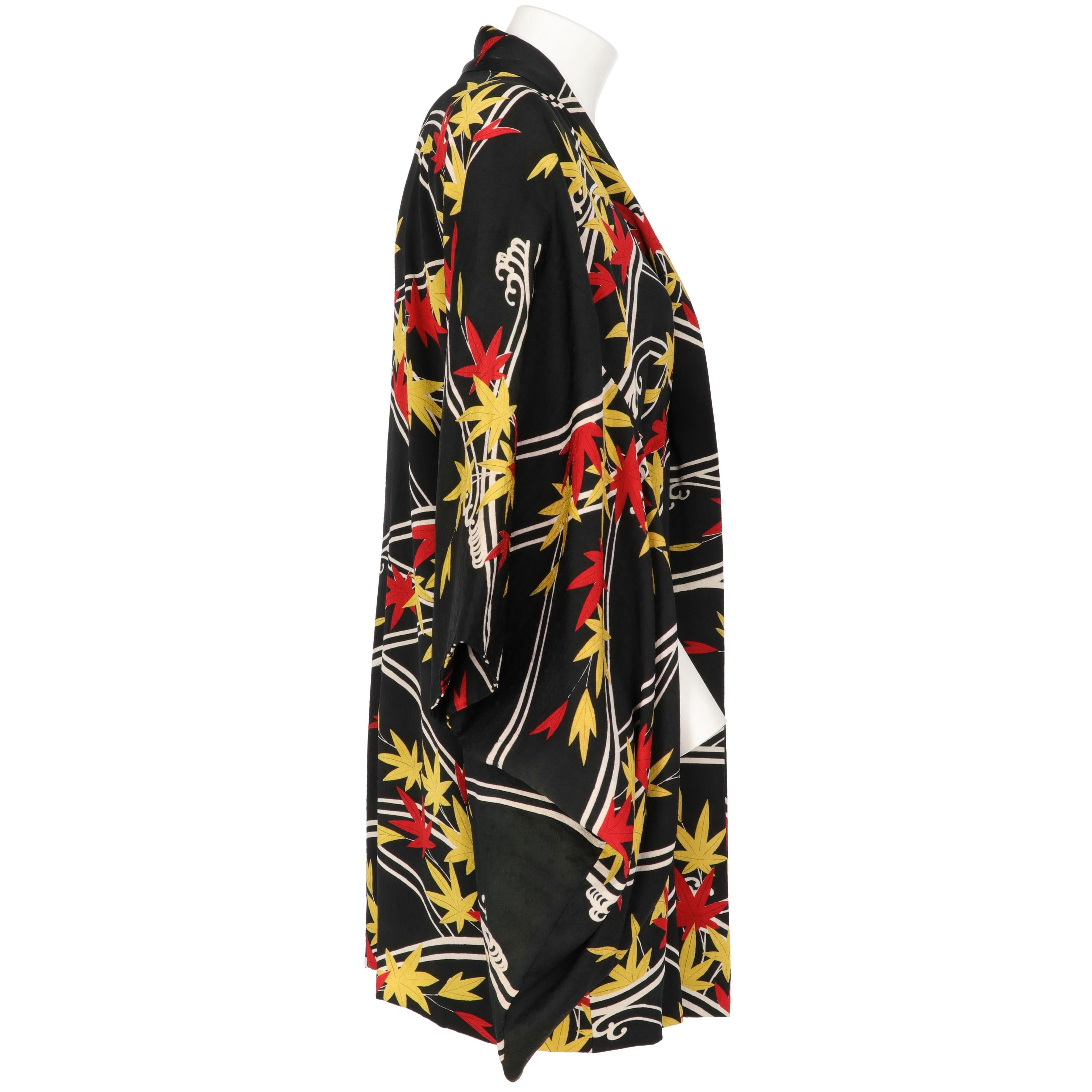 The elegant 70s silk short kimono has been produced in Japan. With white abstract lines and red and yellow autumn leaves fancy print, the kimono features inner laces fastening on the waist and a pink and white flower printed silk lining.

Years:
