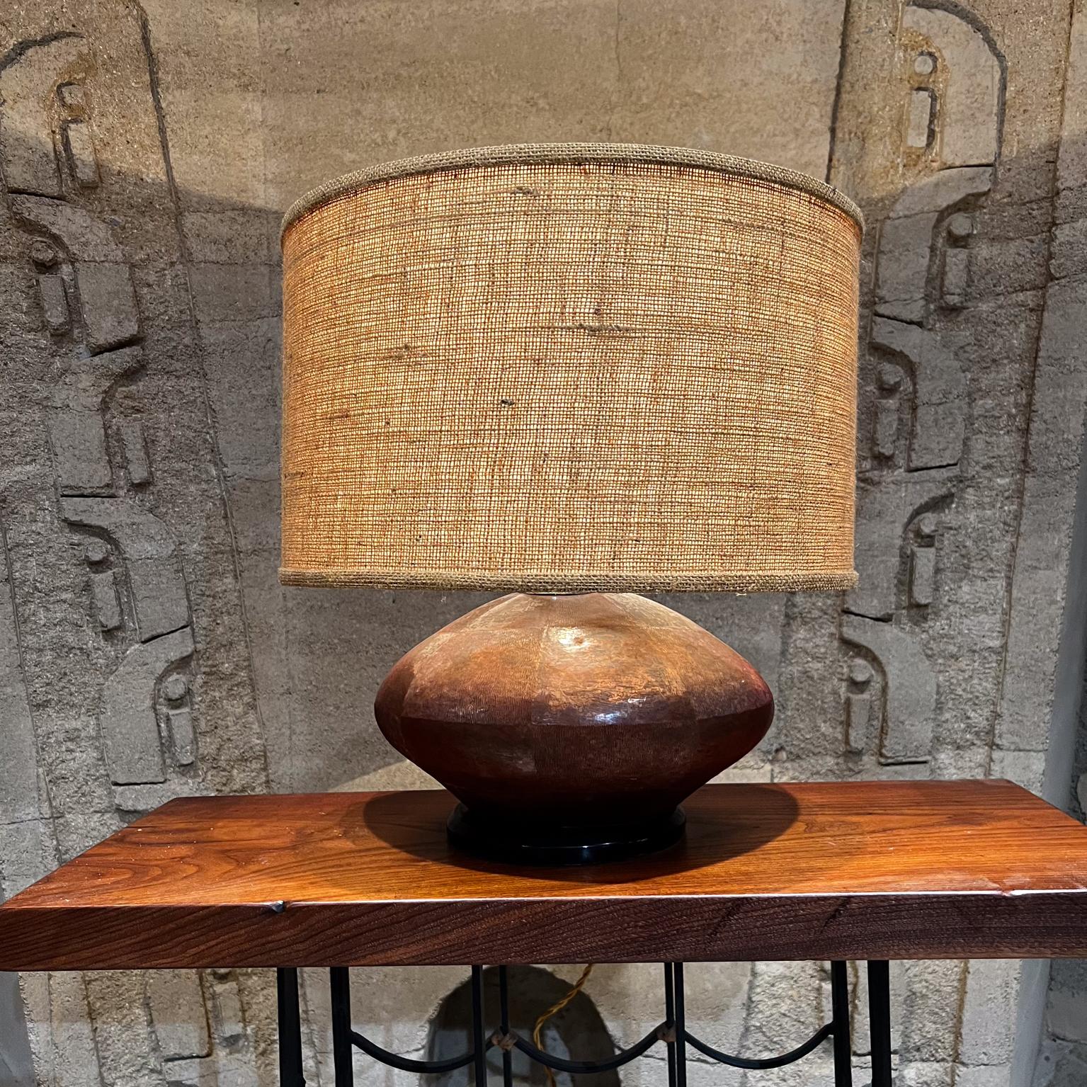 1970s Handmade Texturized Table Lamp Patinated Copper Mexico.
Style of Luis Barragan and Santa Clara de Cobre, Michoacan
Bent wood base painted black.
Brass hardware.
Lamp is fat oval shape.
19 T x 14.5 W x 11.5 D
Original Vintage Preowned