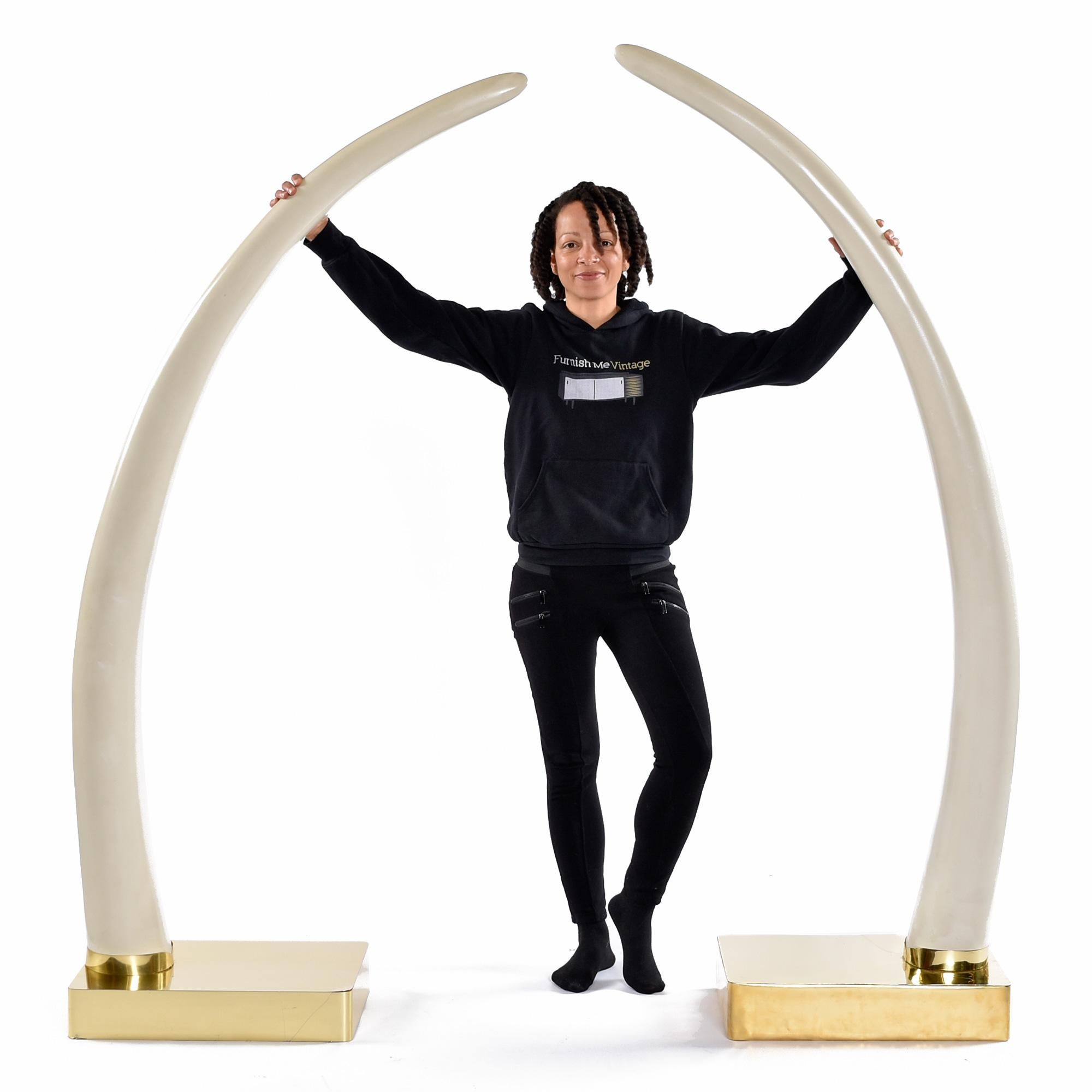 Massive faux-ivory elephant tusks on polished brass bases.  Flank your executive desk with these magnificent show pieces and make a statement.  Ideal for intimidating your business associates during negotiations.  These tusks will look incredible no