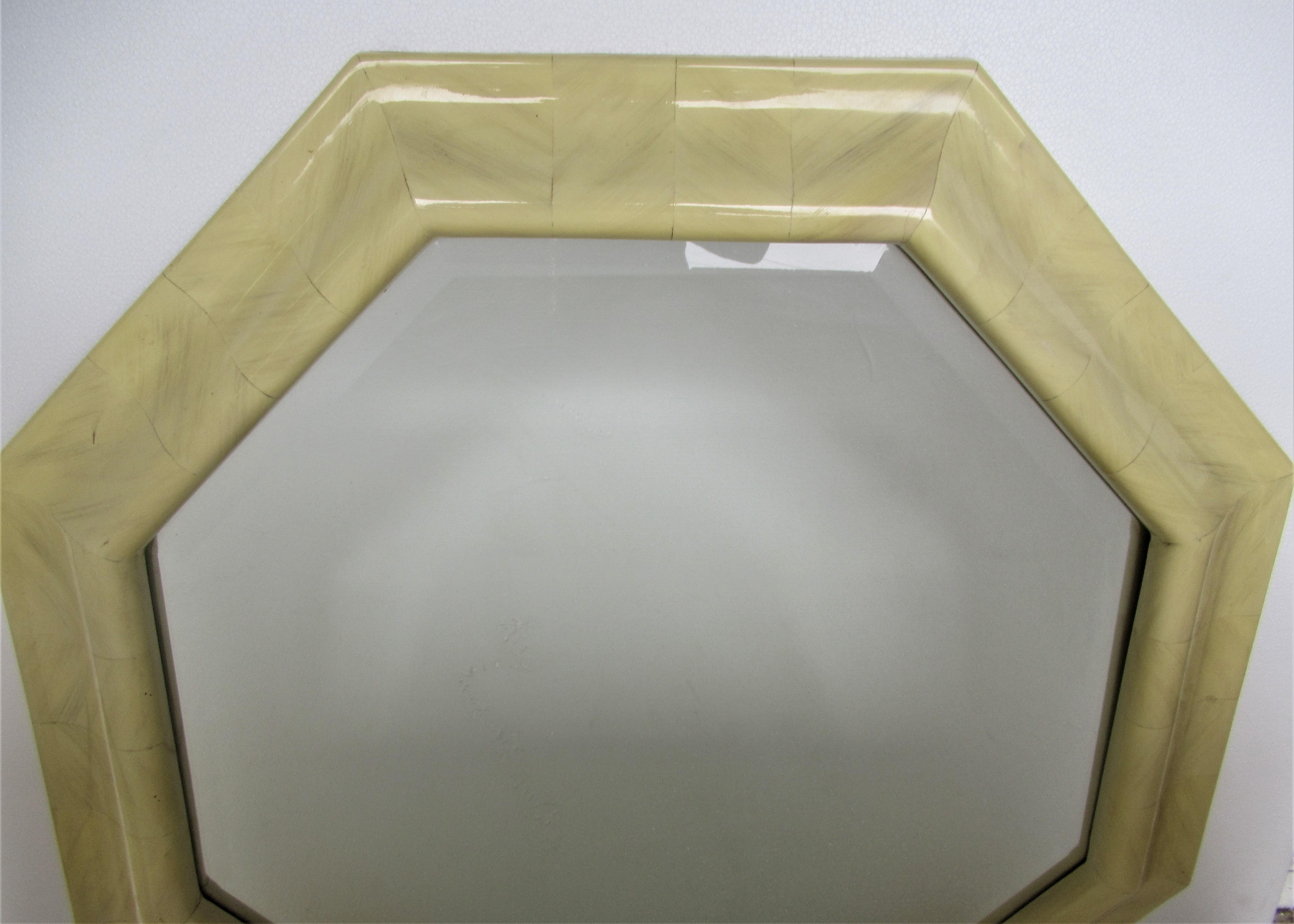 Large 1970s Hollywood Regency shaped octagon frame mirror in lacquered faux ivory parchment resin with beveled plate glass mirror.