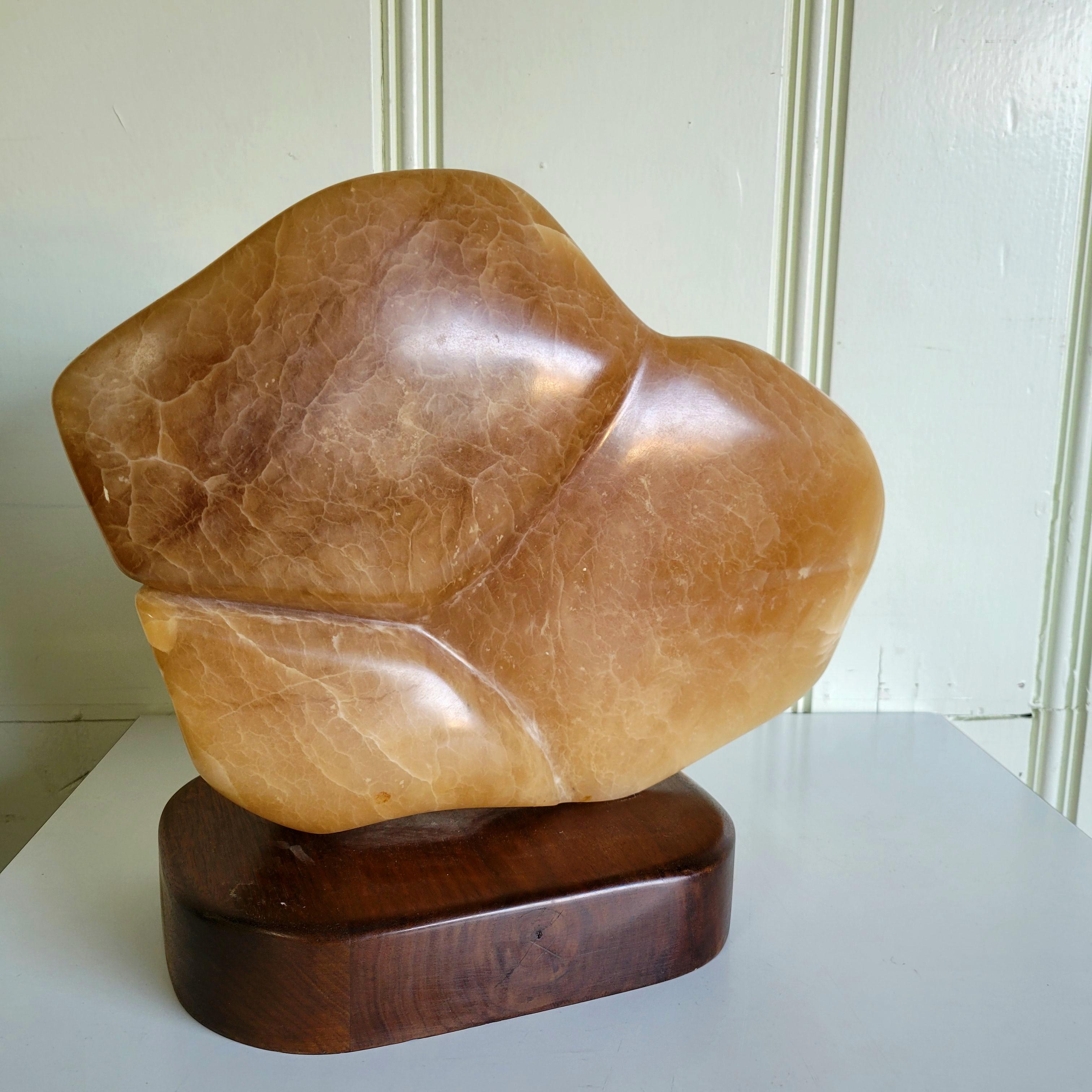 A fantastic piece of stone sculpture depicting the mid torso of a reclining female figure. This piece dates to the 1970s and was acquired with the artists portfolio. I am unsure as to the family of stone it is carved from. Mounted to a walnut base.