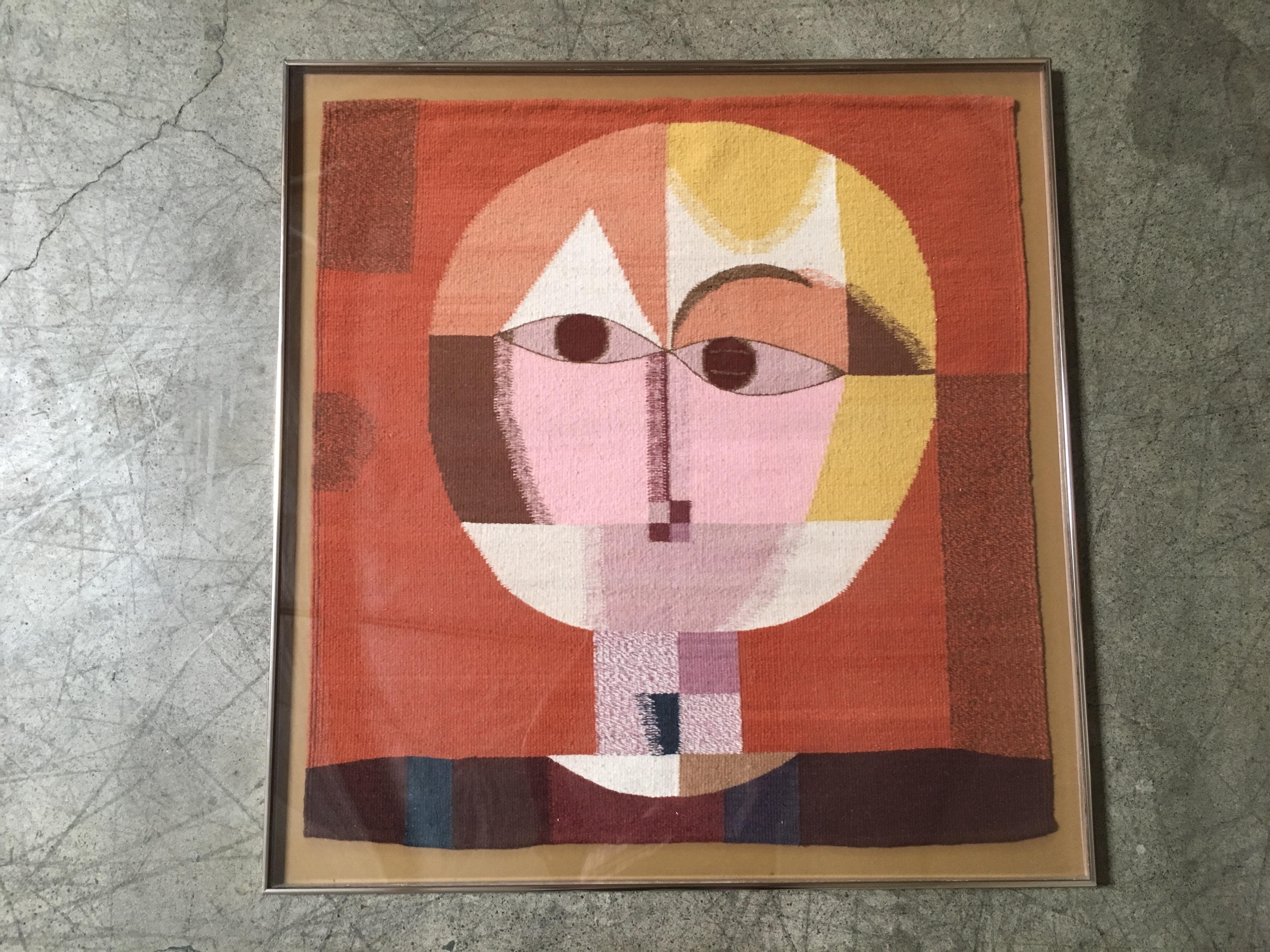 This is a weaving from Oaxaca Mexico taken from Paul Klee titled (Senecio). Framed with Lucite and metal.