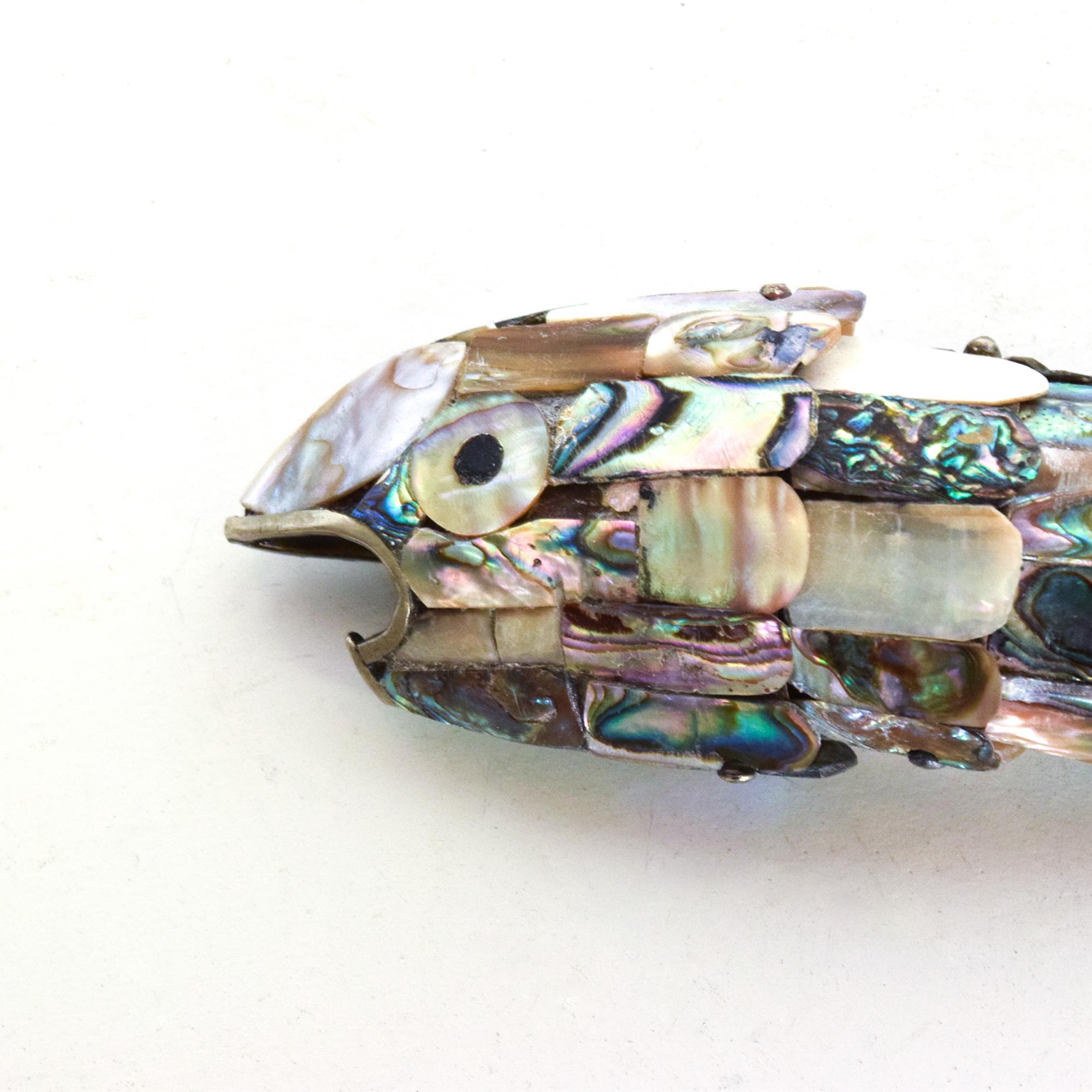 For your consideration: Mexican Modernist sculptural fish bottle opener in Abalone Stone by Los Castillo.
Crafted in Silver Plate, Brass and Abalone.
No markings present. 
Made in Mexico circa the 1970s. 
Dimensions: 8 L x 2 .25H x 1 .5 W.
Very