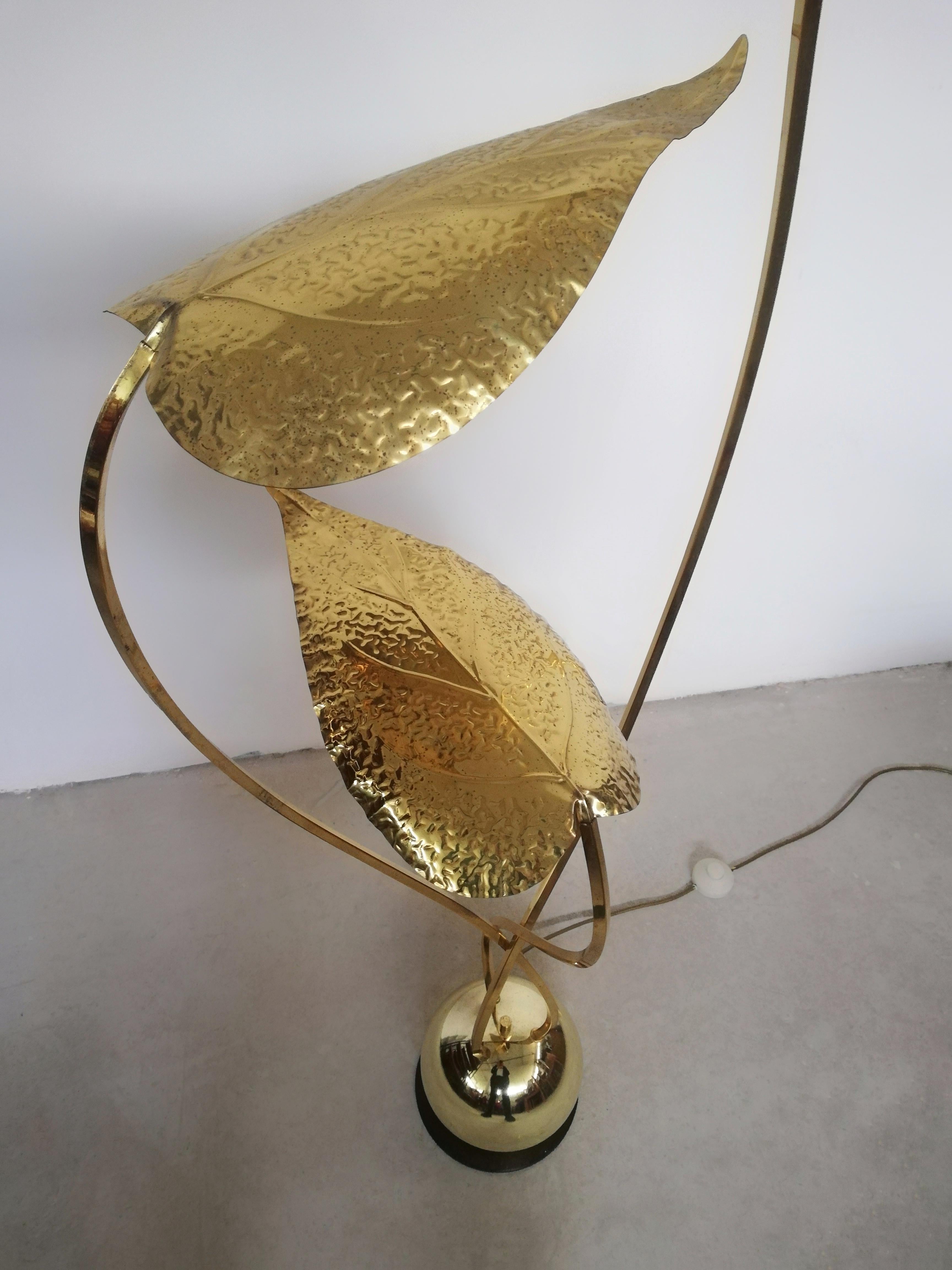 Beautiful floor lamp produced between the 70s and 80s in Italy by Bottega Gadda and designed by Carlo Giorgi.
Three thin stems emerge from a brass-plated metal sphere ending with three large brass leaves that hide three light points.
The brass is