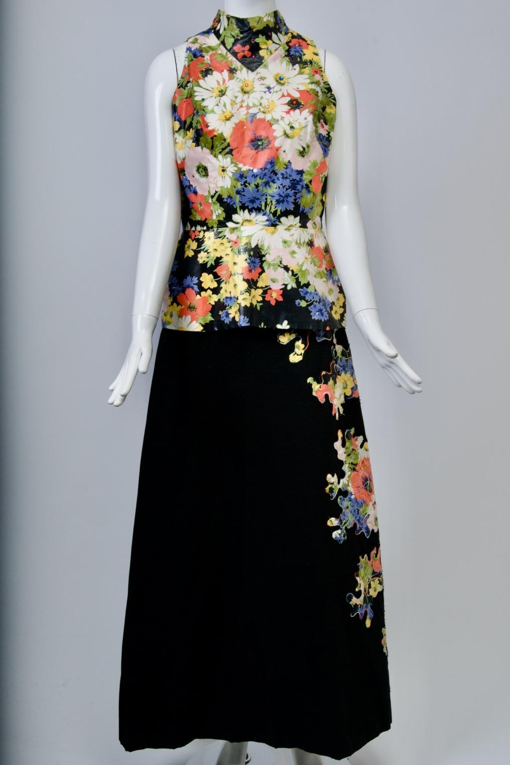 A unique vintage find, this ensemble consists of a long black maxi skirt and sleeveless top, its floral design repeated in cut-out appliqués down the left side of the skirt. the A-line skirt is composed of a ribbed black cotton-type fabric, while