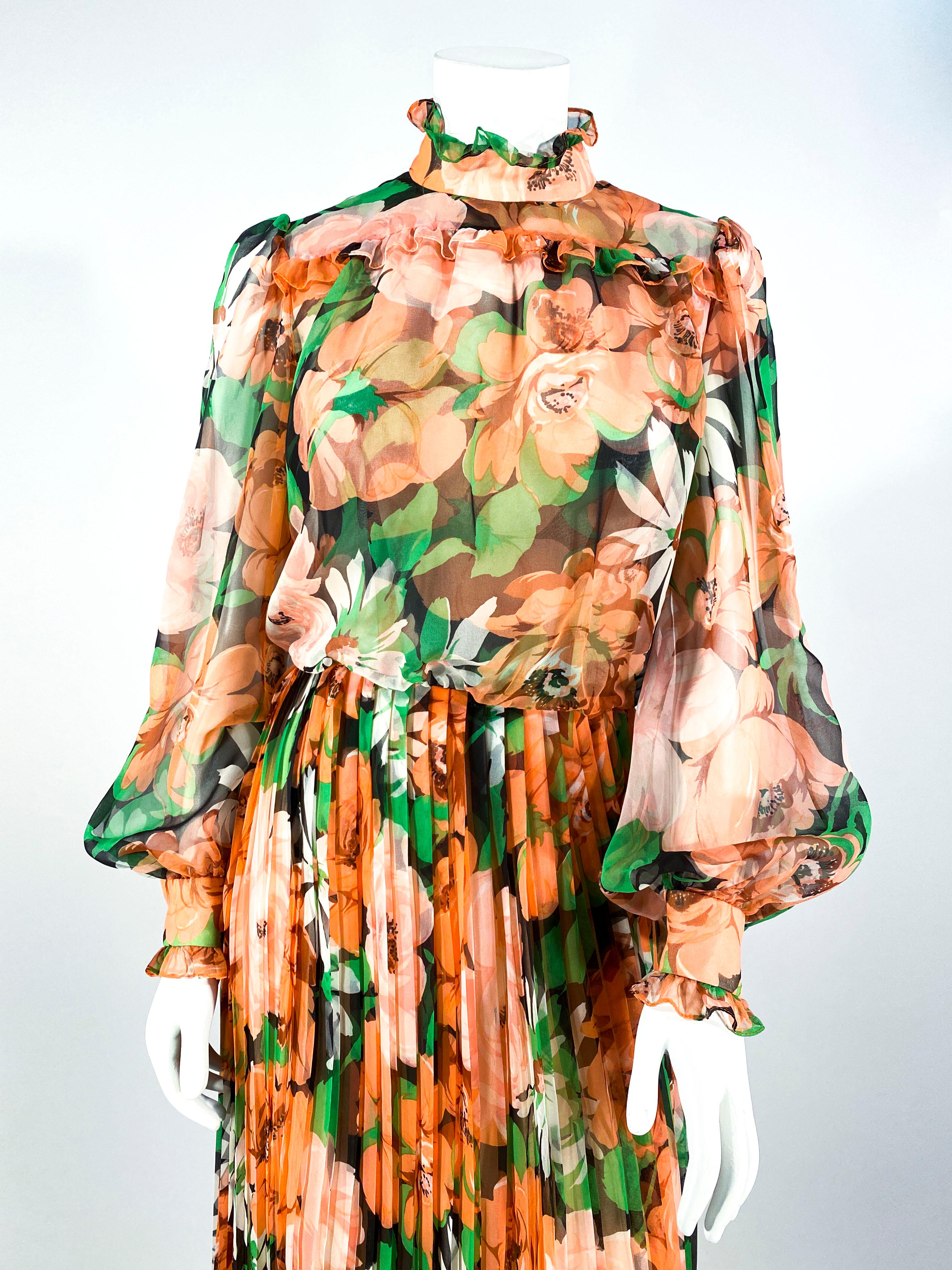 1970s floral printed chiffon prairie dress featuring sheer full length bishop sleeves, ruffled cuffs, a pleated skirt, high-neckline, and ruffle trim along the bloused bodice. The pleated skirt extends to ankle length and is lined.