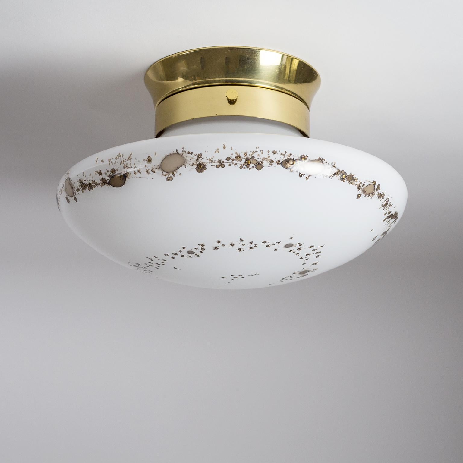 Very fine 1970s glass mushroom flush mount. A sleek brass ceiling unit holds a 'mushroom' blown glass diffuser which has gold-metallic inclusions applied in a spiraling shape. Excellent original condition with one E27 socket and manufacturers label