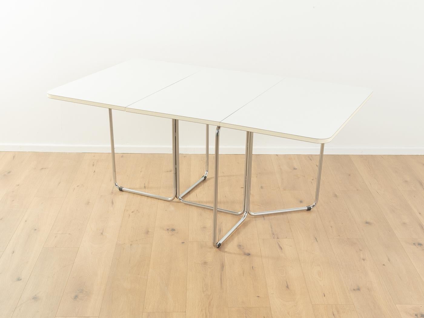 Rare folding table by Christian Taube for Läsko from the 1970s. Solid frame made of chrome-plated tubular steel and a table top with original white formica coating.

Quality Features:

    very good workmanship
    high-quality materials
    Made in