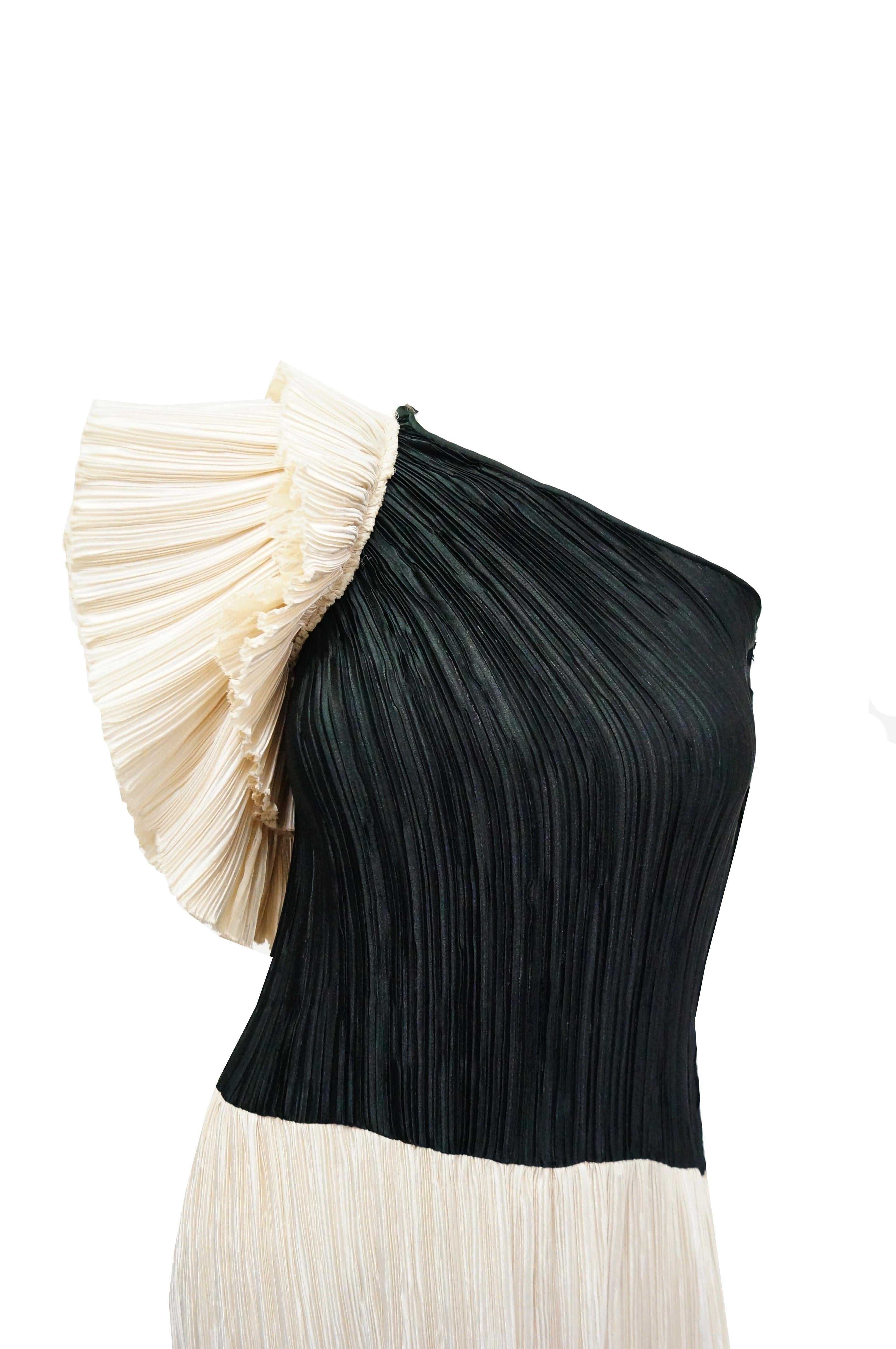Beautifully done Fortuny style black and white pleated off the shoulder minimalist evening dress. Column silhouette with a lovely layered flounce detail. The use of black and white paired with a one shoulder  flounce add quiet drama, creating class