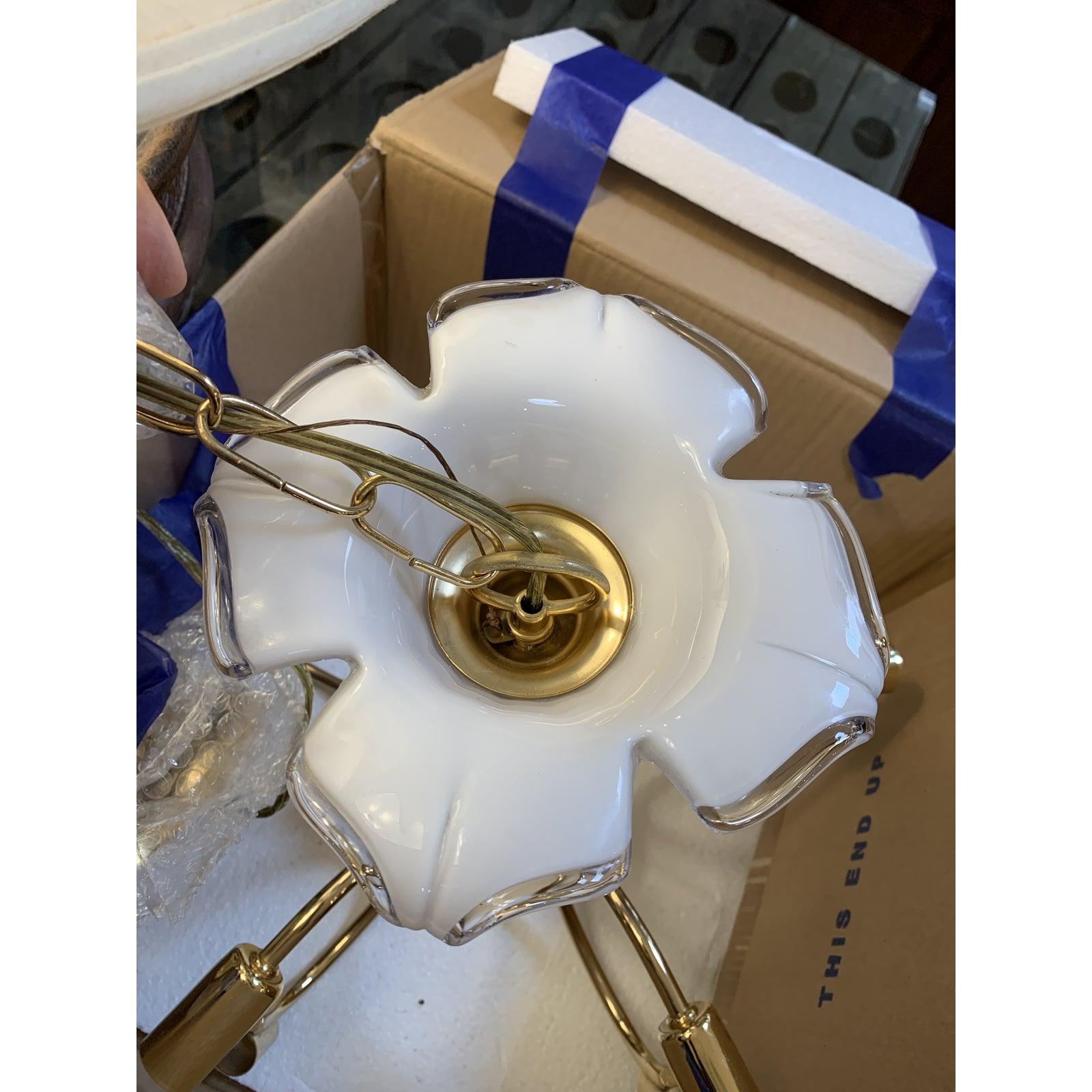Presents a Murano glass Calla Lily chandelier by Franco Luce. Mid-20th century styling is showcased with the polished brass and hand blown Murano glass Lily discs. There are five Lilies which radiate light from the center. Center lily houses the