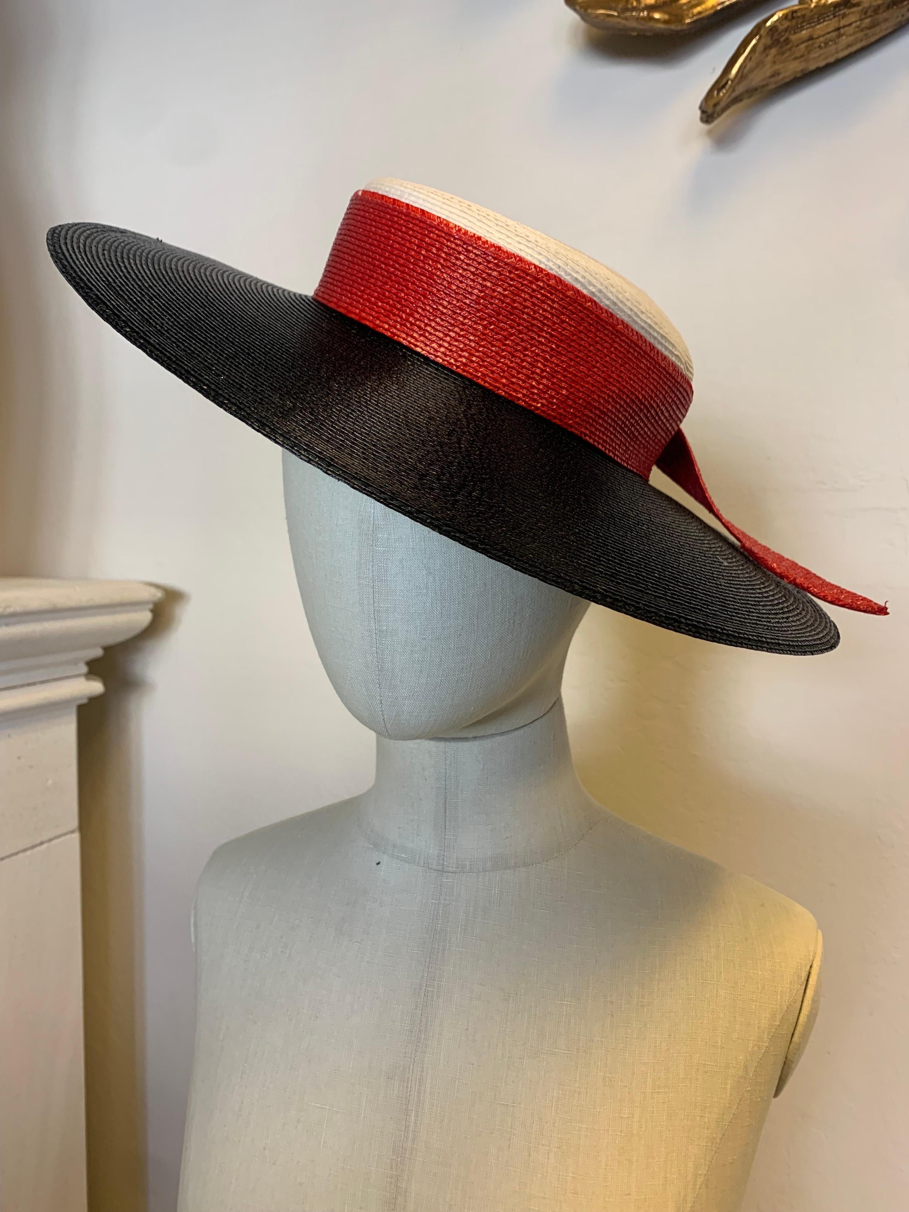 A fabulous 1970s Frank Olive (Private Collection) straw fedora: Wide black brim with low white straw crown is trimmed with a red straw knotted band. A fabulous classic summer accessory to wear at a jaunty angle!  Size Medium. 